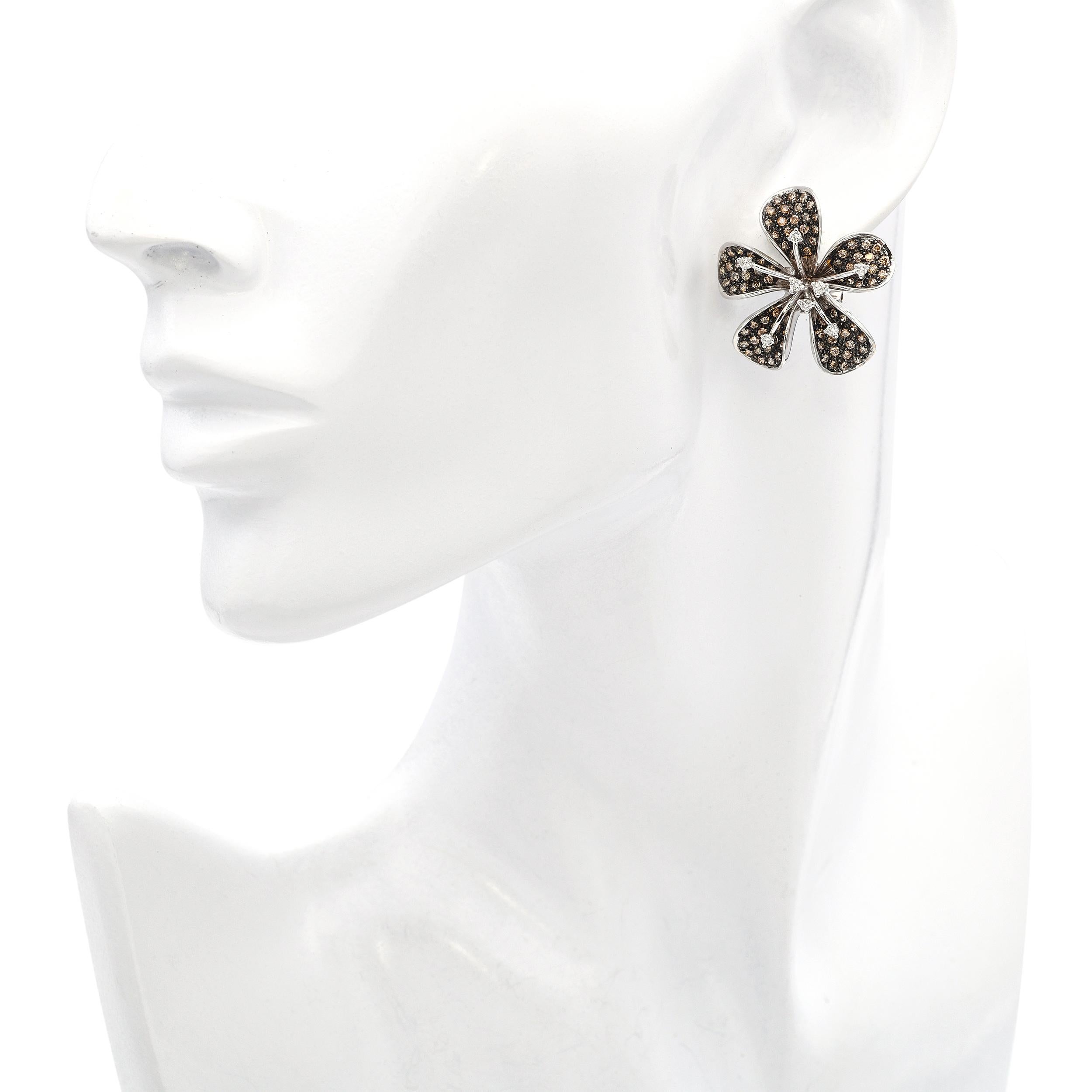 These elegant earrings are crafted in luxurious 18k white gold and designed in the shape of delicate plumeria flowers. Each petal is gracefully contoured and accented with sparkling diamonds, creating a soft yet radiant bloom. The center of each