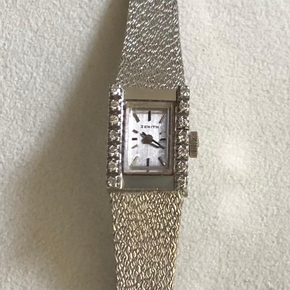 18K White Gold Zenith ladies watch with diamonds. 
a truly Watch-jewel with hand-wound mechanical, rectangular case with seven diamonds per side for a total of 14. Bracelet and clasp are original and in 18K white gold. 
The clasp allows for 2