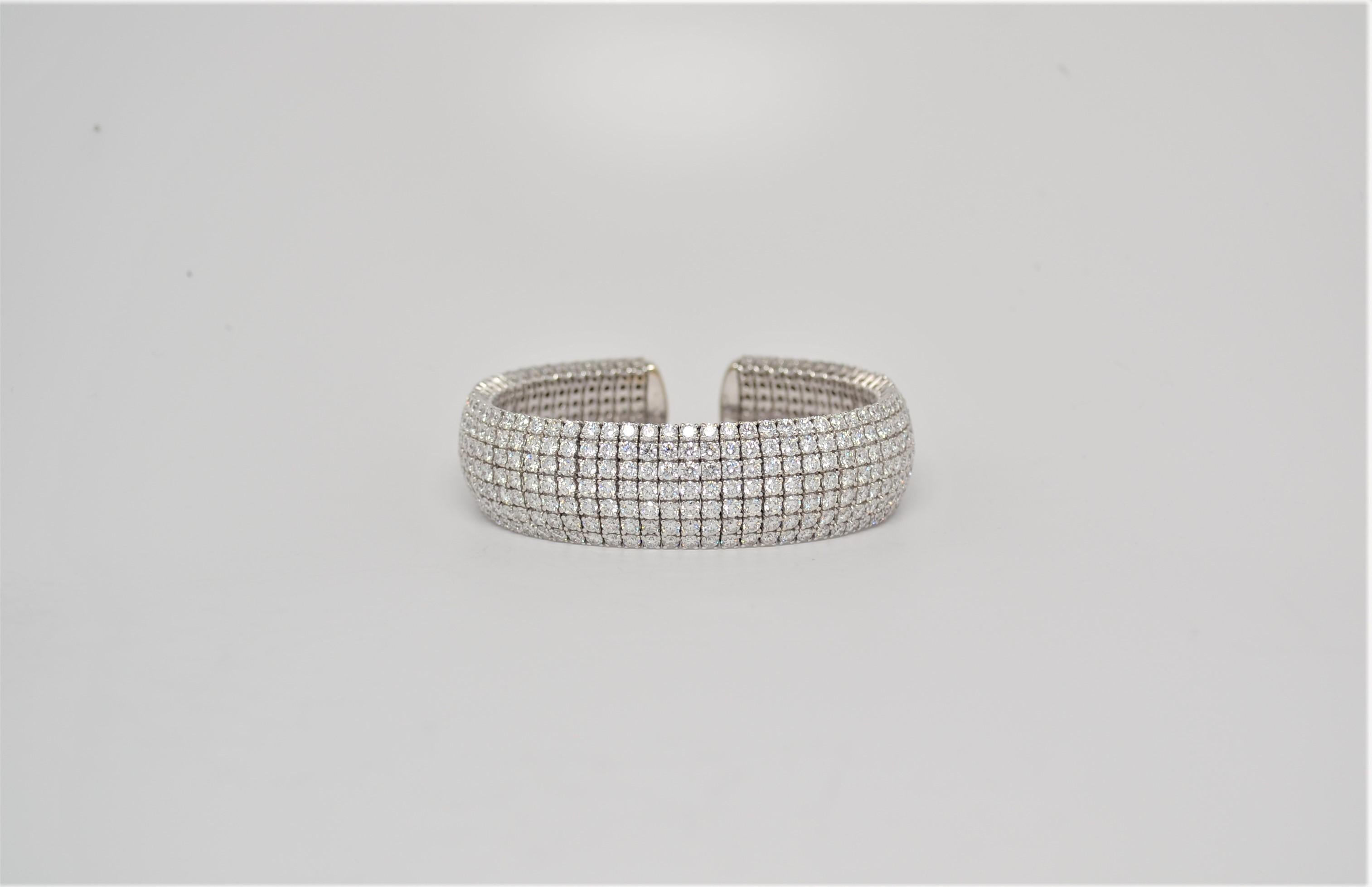 A unique ladies' 18K White Gold bangle bracelet with Diamonds. The bracelet is open ended with flexible prong settings for a comfortable fit. A total of four hundred and thirty four Round Brilliant Cut Diamonds weigh 23.25ct total, color grade range