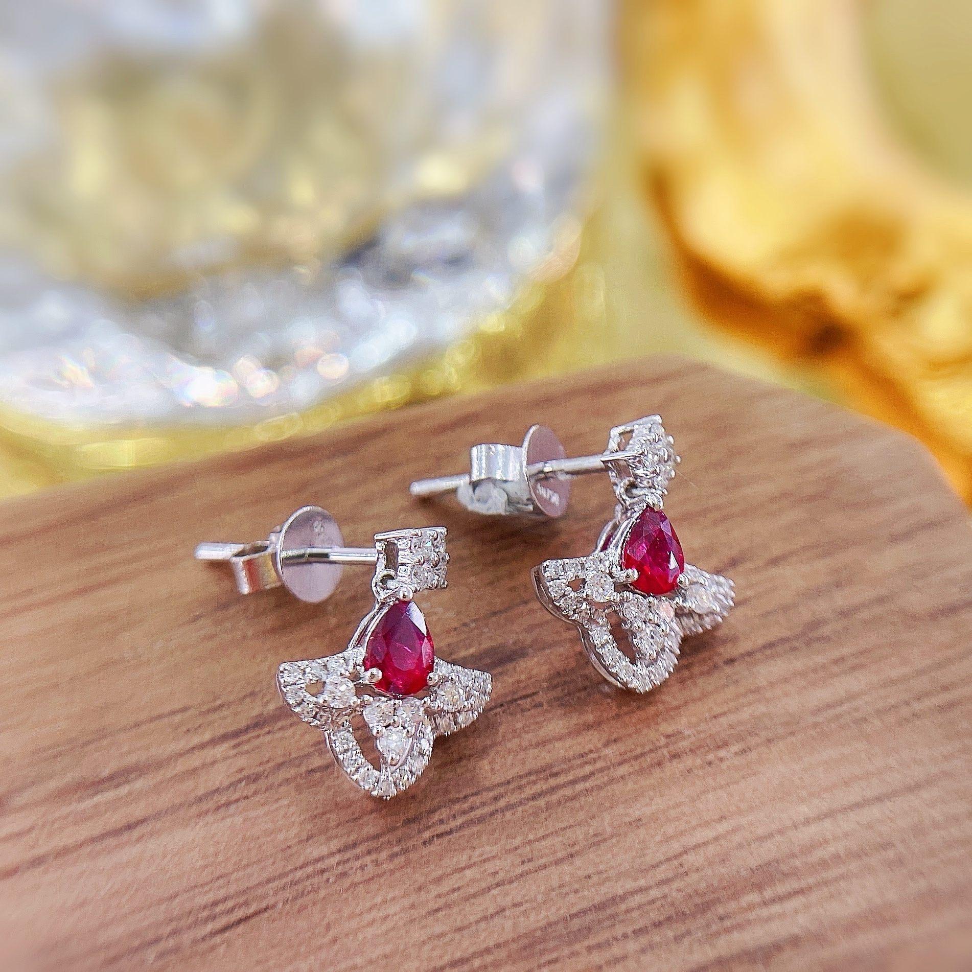 Total Weight: 1.63 g
Net Gold Weight: 1.512 g
Main Stones: 2 Rubies, 0.370 CT
Secondary Stones: 56 Diamonds, 0.220 CT

These elegant drop earrings feature a teardrop design inspired by the flow of a dress, crafted in white gold with vibrant rubies