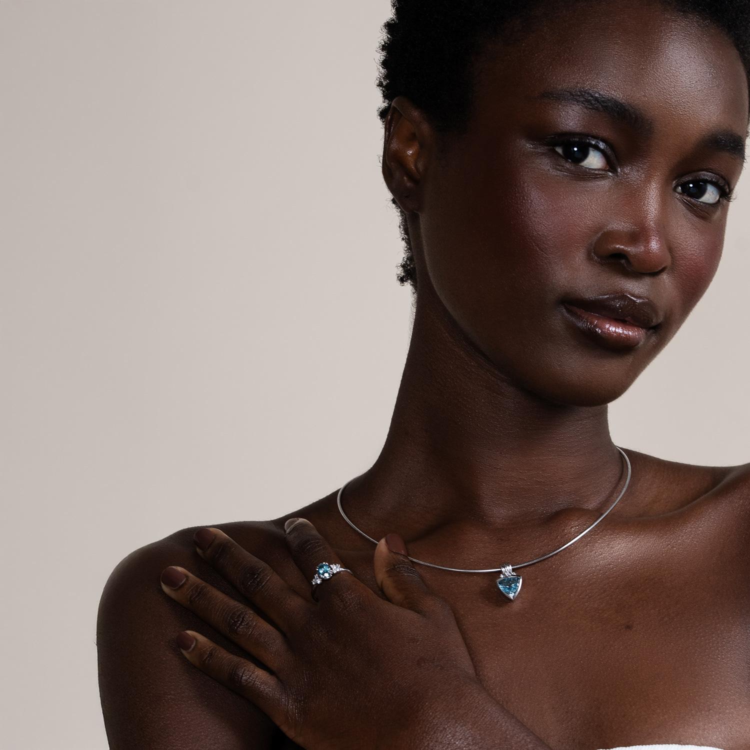 This striking aquamarine trillion pendant from the classic Aurora collection is set in a chunky 18k white gold bezel with a fluted bail, accented with three small diamonds for added sparkle. The pendant hangs on a sleek flexible snake chain torque