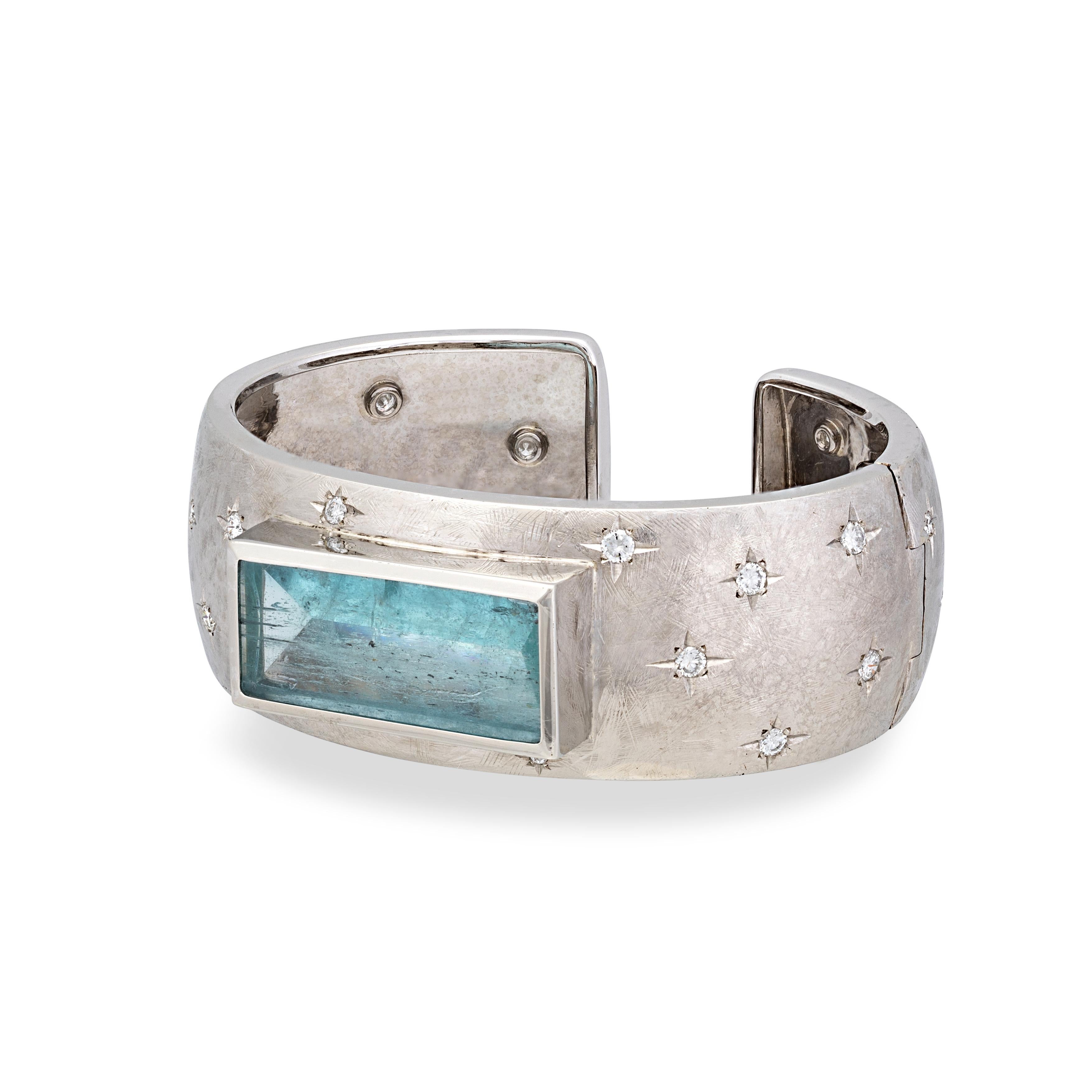 This sleek cuff style bracelet with a hidden spring hinge opening is a sophisticated piece of jewelry. Meticulously handcrafted in 18k white gold, and interspersed with 24 scintillating diamonds set in a dazzling star pattern in the band, this