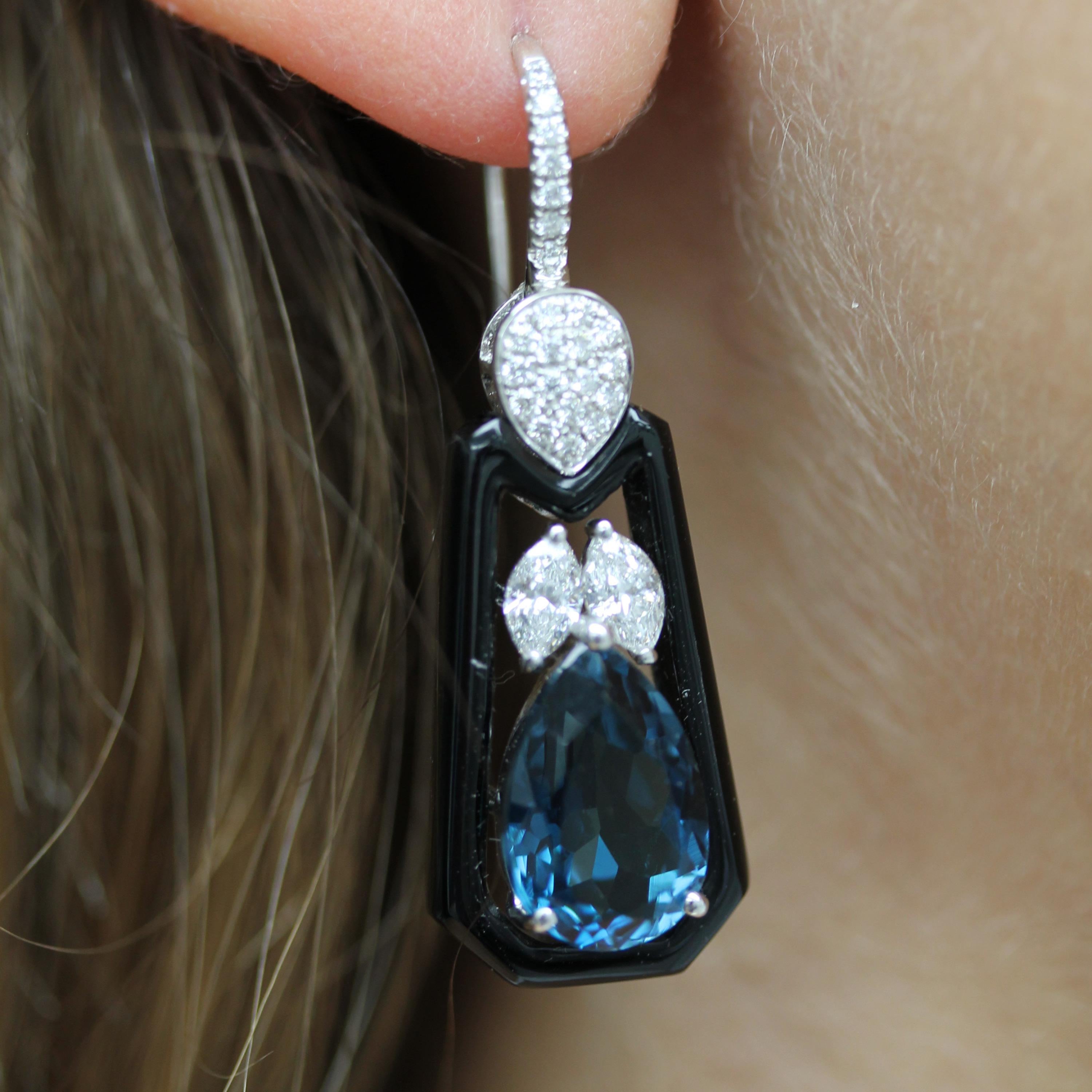 Art-Deco Style Earrings featuring Pear-Shaped London Blue Topaz, Black Onyx, and Marquise and Round Diamonds, set in 18K white gold. French Wire Backs. London Blue Topaz stone used is natural, untreated, and a deep indigo blue. The December
