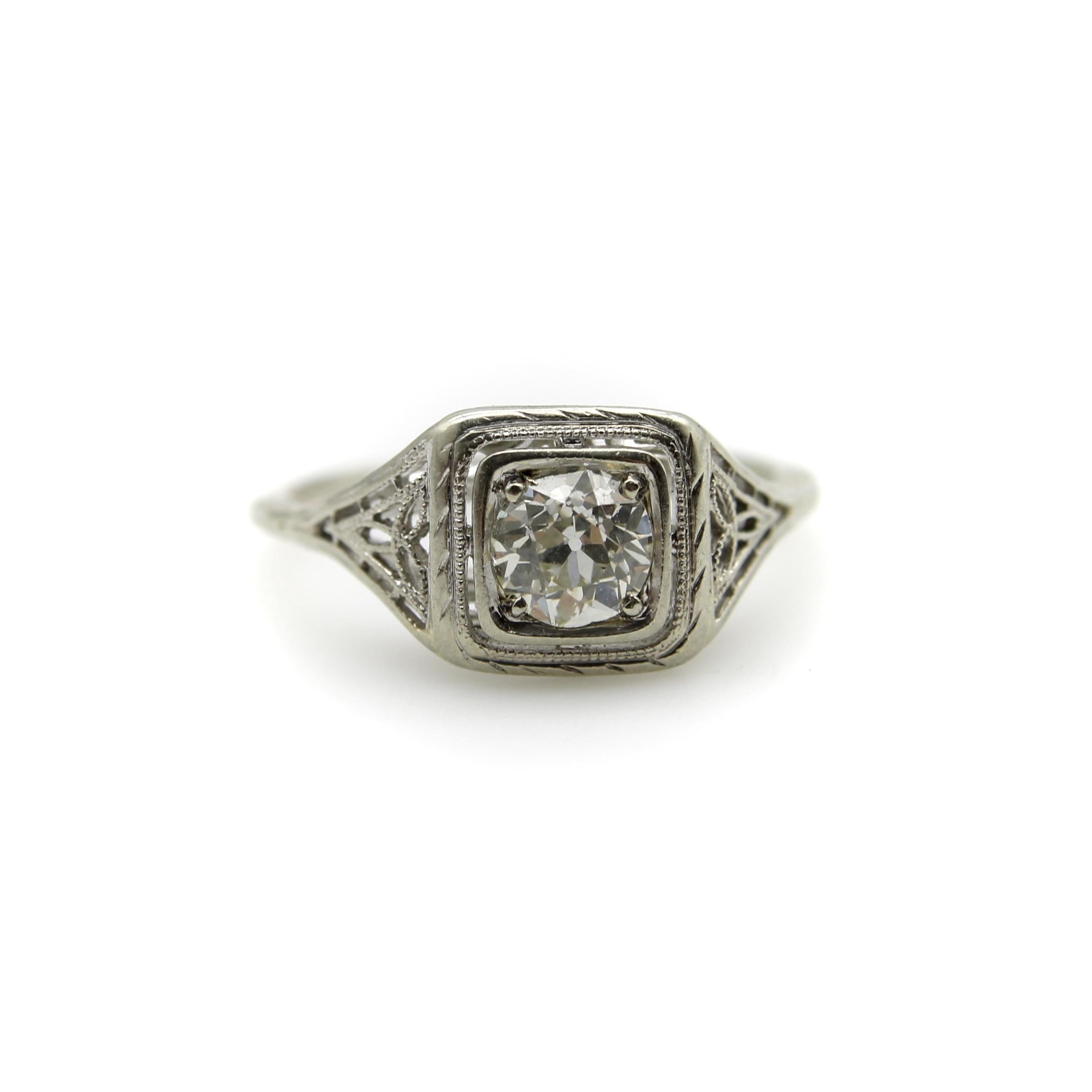 Cette bague à diamant en or blanc 18 carats présente tous les éléments classiques d'une belle bague Art déco. Le diamant Old European Cut de 0,55 carat est maintenu dans une monture carrée entourée d'un travail ouvert, créant l'apparence que la