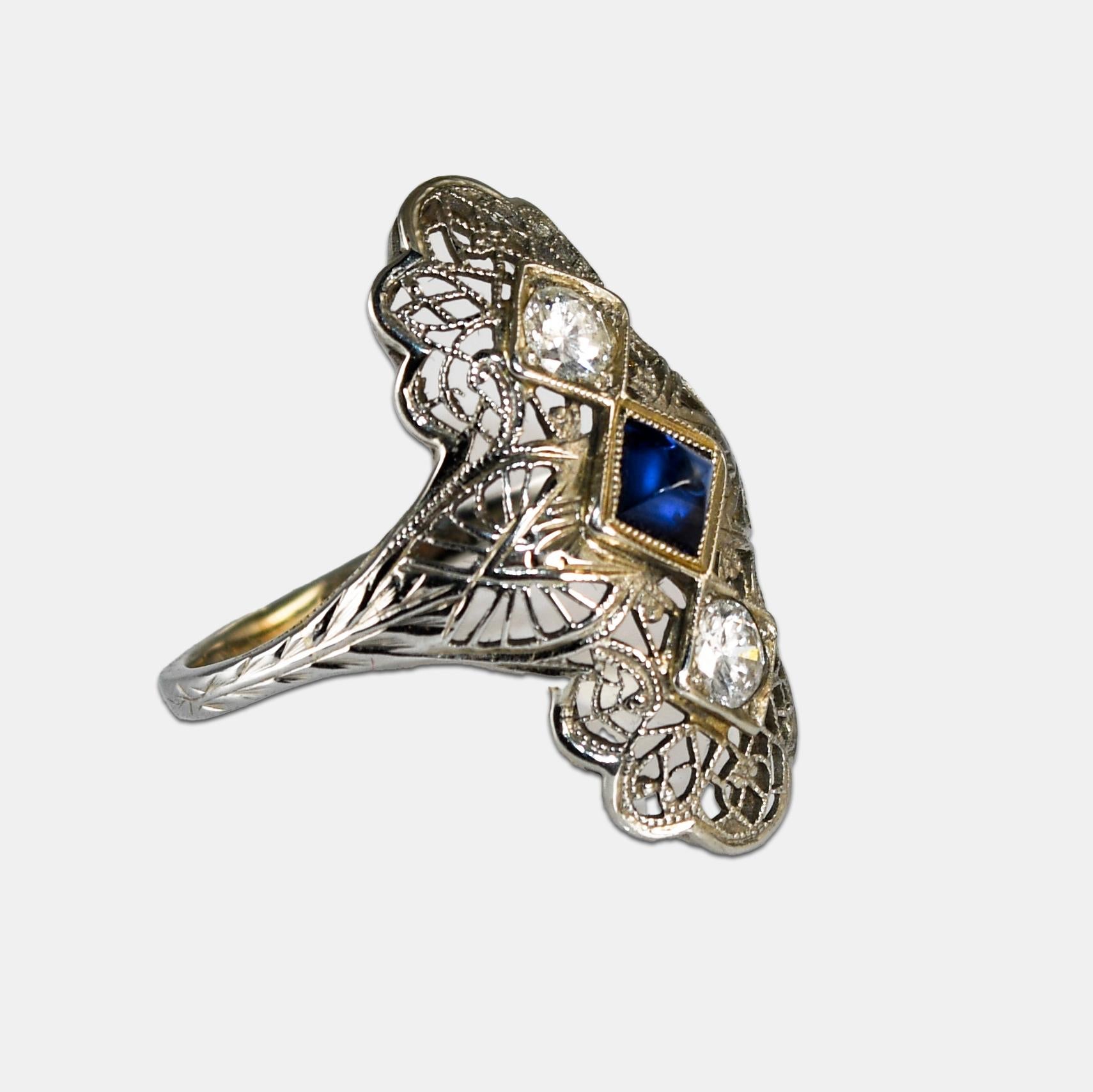 18k white gold Art Deco Ladies ring with diamonds and blue sapphire.
The center stone is a round 0.20 carat blue sapphire.
There are two round brilliant cut diamonds with a total diamond weight of 0.30ct with VS clarity and I color.
This ring has