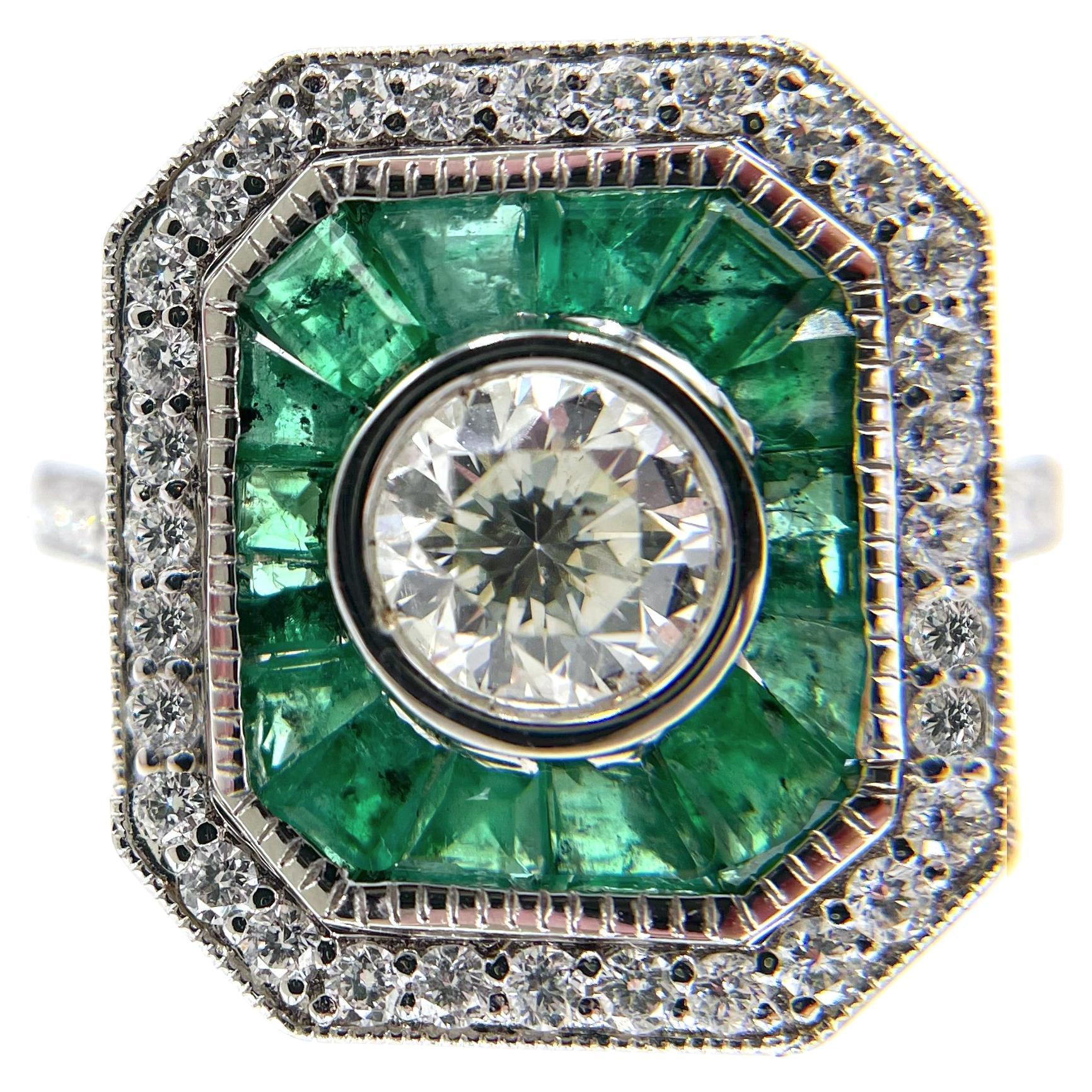 18K white gold Art Deco inspired ring furnished with baguette cut emeralds weighing 1.00 carats total and round faceted diamonds weighing 0.44 carats total.  In the center, one round old cut diamond weighing 0.62 carats (J color, SI2 clarity).

*