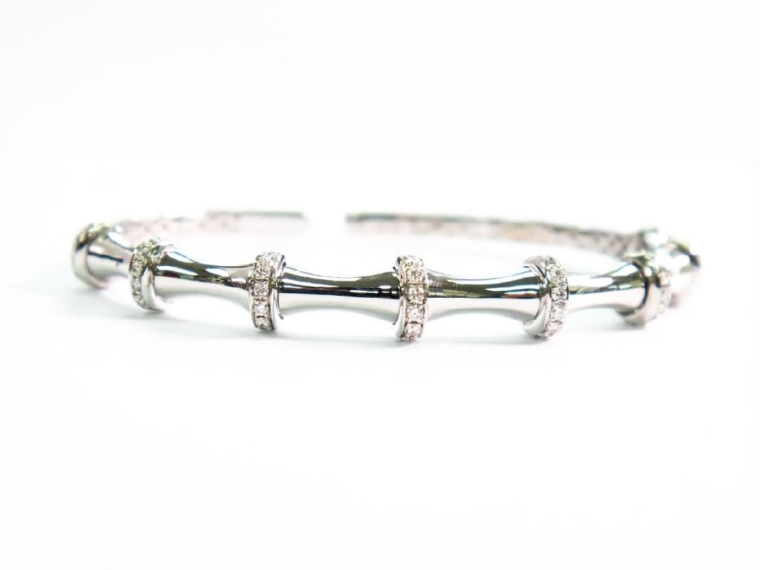 •	Metal: 18K White Gold 
•	Weight: 12.81gm
•	Gemstones: Natural Diamonds
•	Total Diamond Weight: 0.86ct (64 stones)
•       Diameter of bracelet: 1.8 inch - 2.3 inch
A symbol of renewal and grace, this elegant white gold bangle is adorned with 64