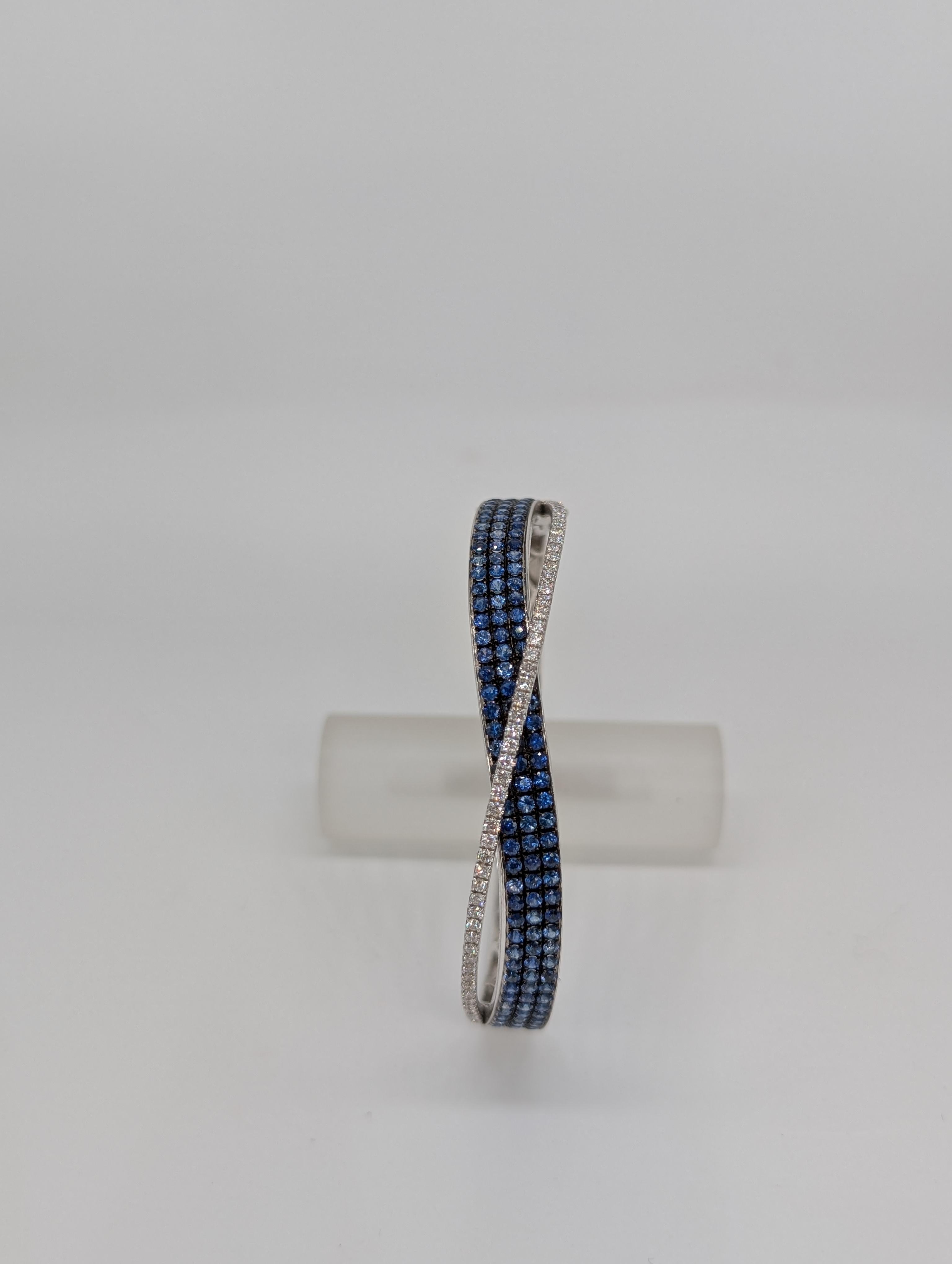 Dieser exquisite Armreif aus 18-karätigem Gold kombiniert kühnes Design mit luxuriösen Edelsteinen. Mit 6,15 Karat atemberaubenden blauen Saphiren und 1,20 Karat Diamanten im Brillantrundschliff besticht dieses Schmuckstück durch Eleganz und