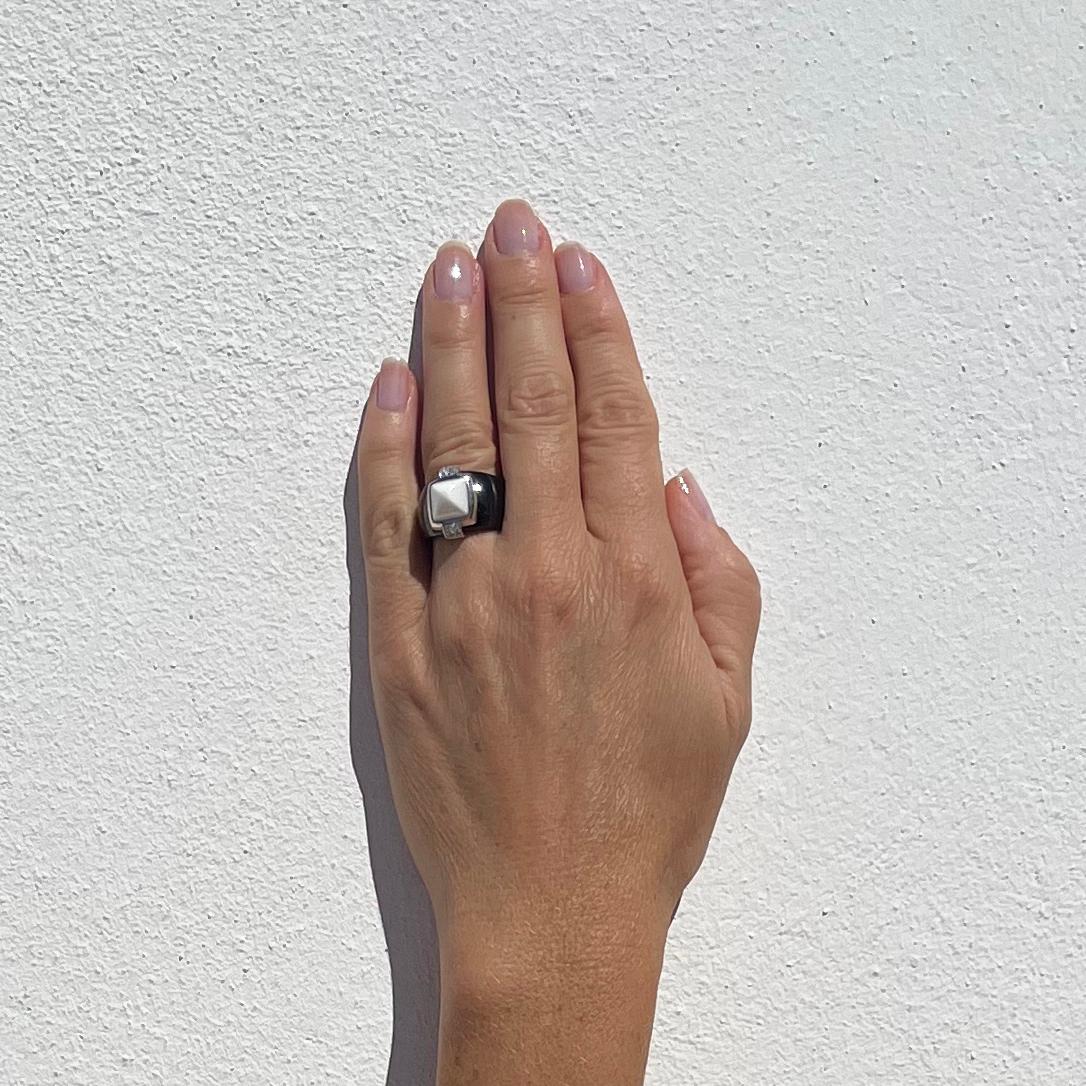 This onyx ring is adorned with a white onyx centre piece which is placed in a 18 karat white gold and eight brilliant cut diamonds (approx. 0,12 ctv) setting. The beautifully arched black onyx shank is massive making it not only a necessity, but yet