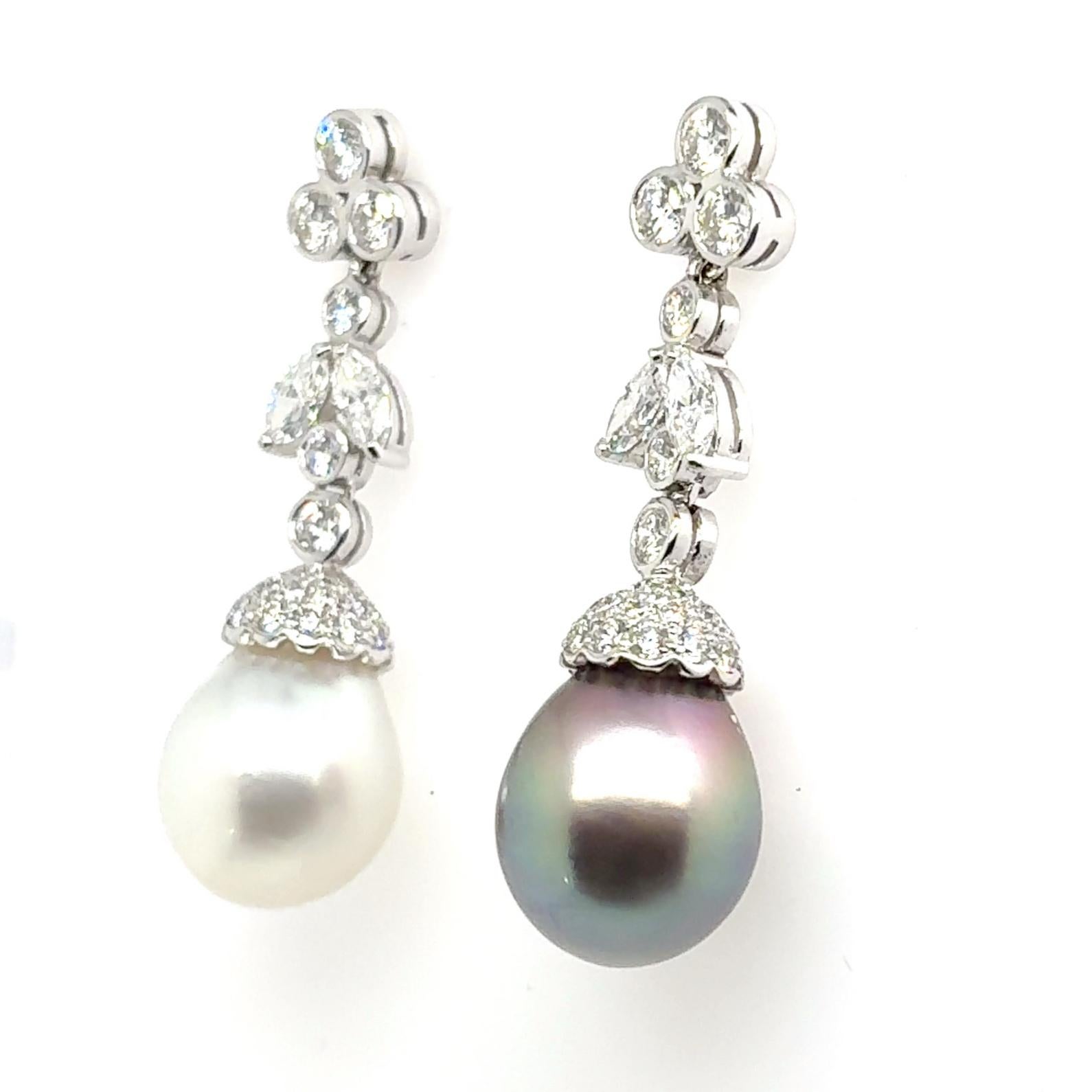 Ces boucles d'oreilles de 40 mm présentent une perle blanche lumineuse des mers du Sud et une perle noire mystérieuse des mers du Sud, chacune d'une taille généreuse de 13,4 x 17 mm, suspendues sous 3,96 cts de diamants étincelants en or blanc 18
