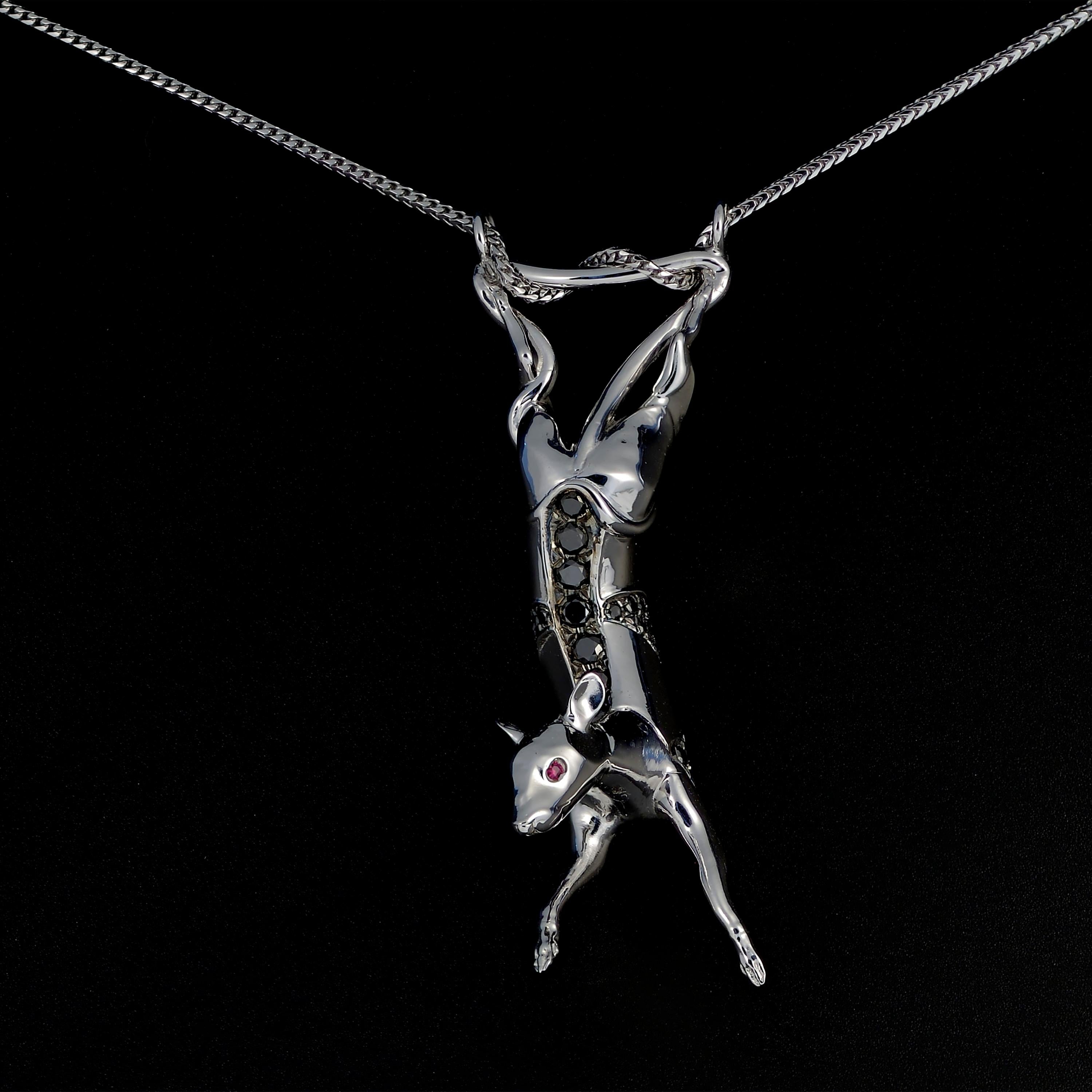 Unique sculptural pendant necklace in 18K white gold set with black diamonds and rubies. 

Created in a mix of Contemporary and Art Deco styles, this figurine of a rat dangling by its tail looks surprised but calm. Panels of darkened gold and black