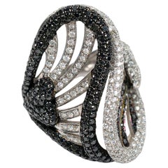 Anillo de cóctel llamativo de oro blanco de 18k con pavé de diamantes blancos y negros en forma de onda en espiral