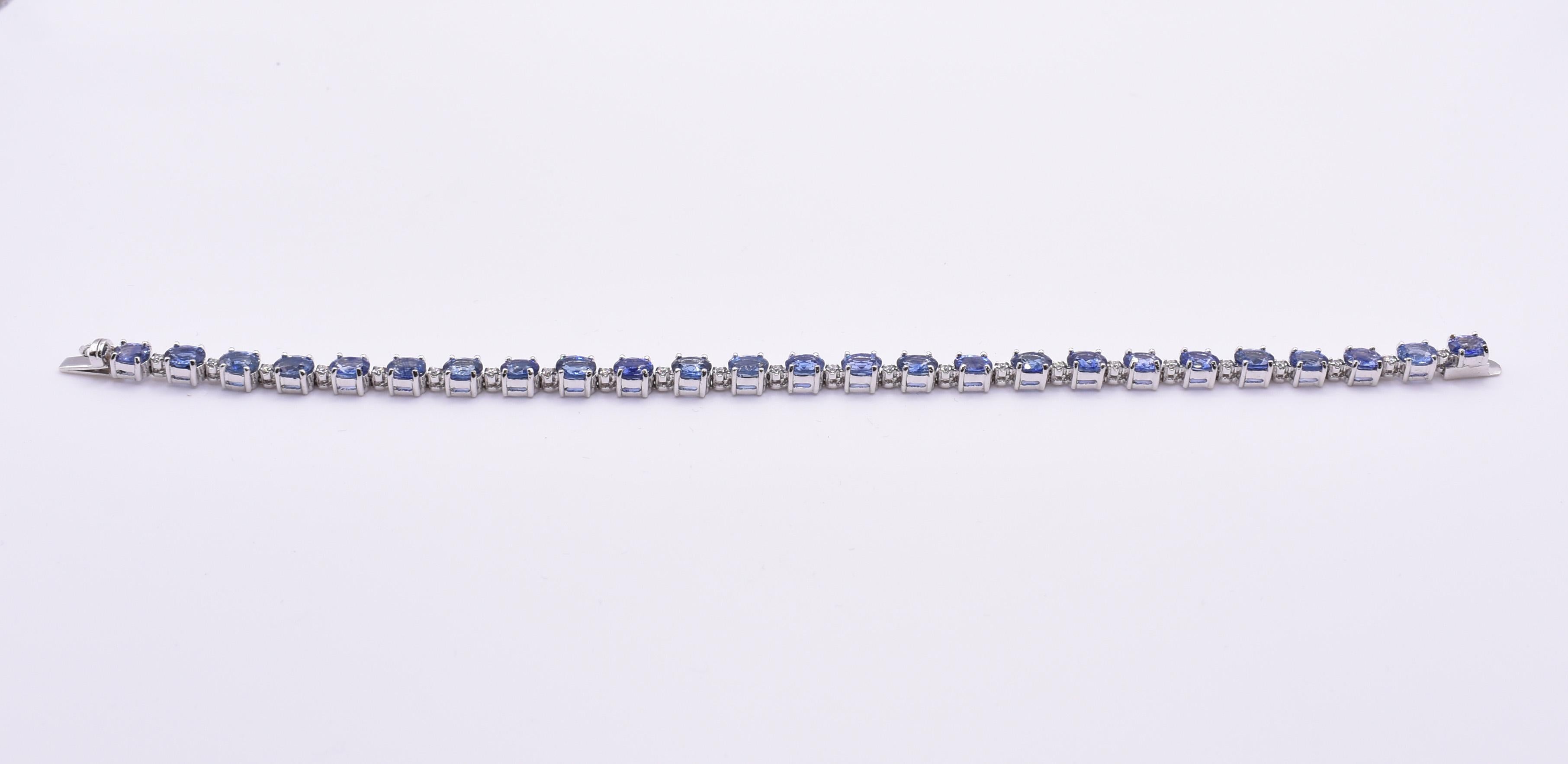 A Fabulous 18k white gold & blue sapphire tennis bracelet, featuring a total of 25 blue Ceylone sapphires, each prong set, separated by a total of 24 round cut diamonds. Sapphires = 12.65ct Diamonds = 0.27ct Gold weight = 10.52g. Length: 19cm