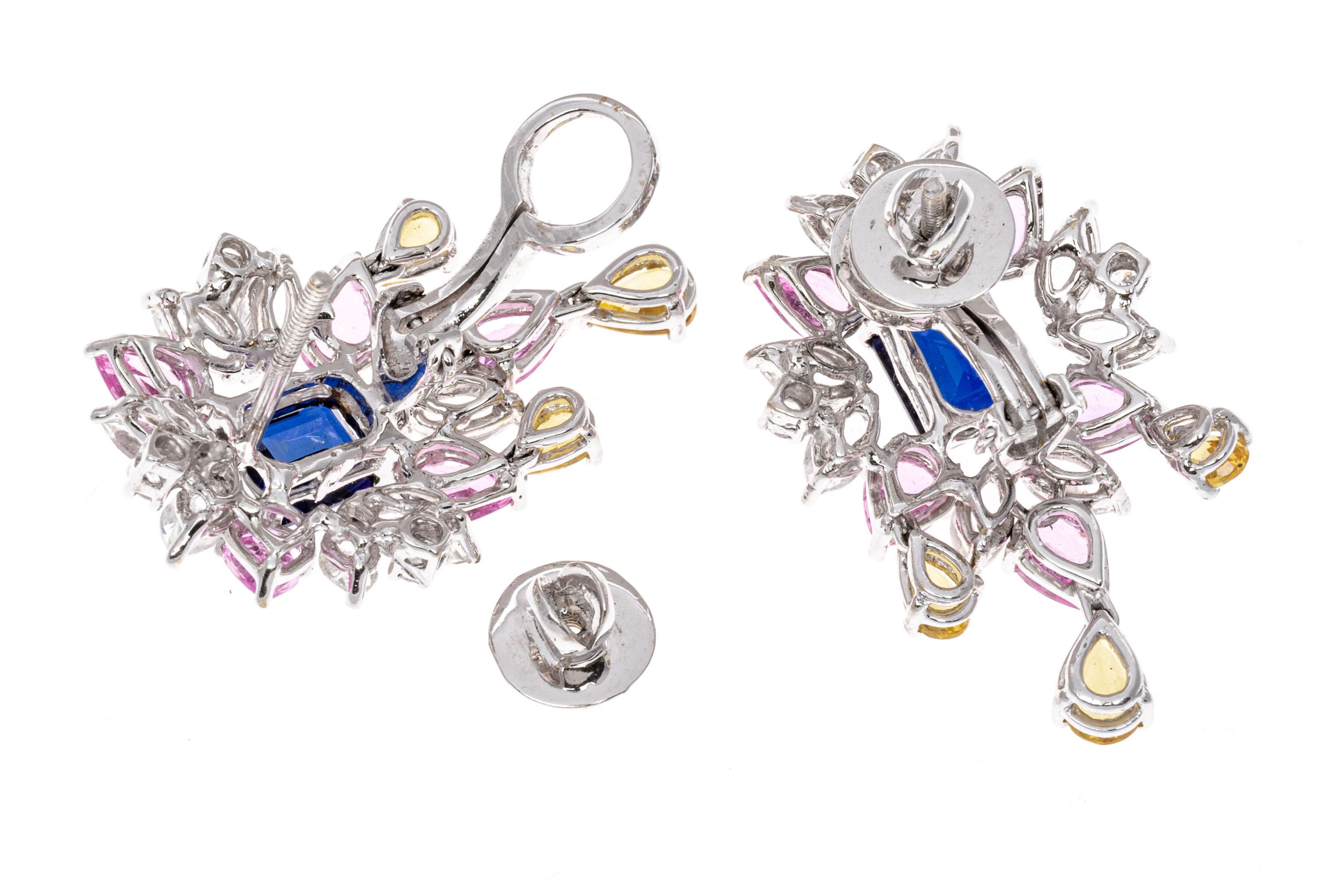 18K White Gold Colorful Blue, Pink, Yellow And White Sapphire Cluster Earrings. These amazingly colorful earrings are a cluster style, with a center emerald cut deep navy blue synthetic sapphire center stone. Surrounding the center are a cluster of