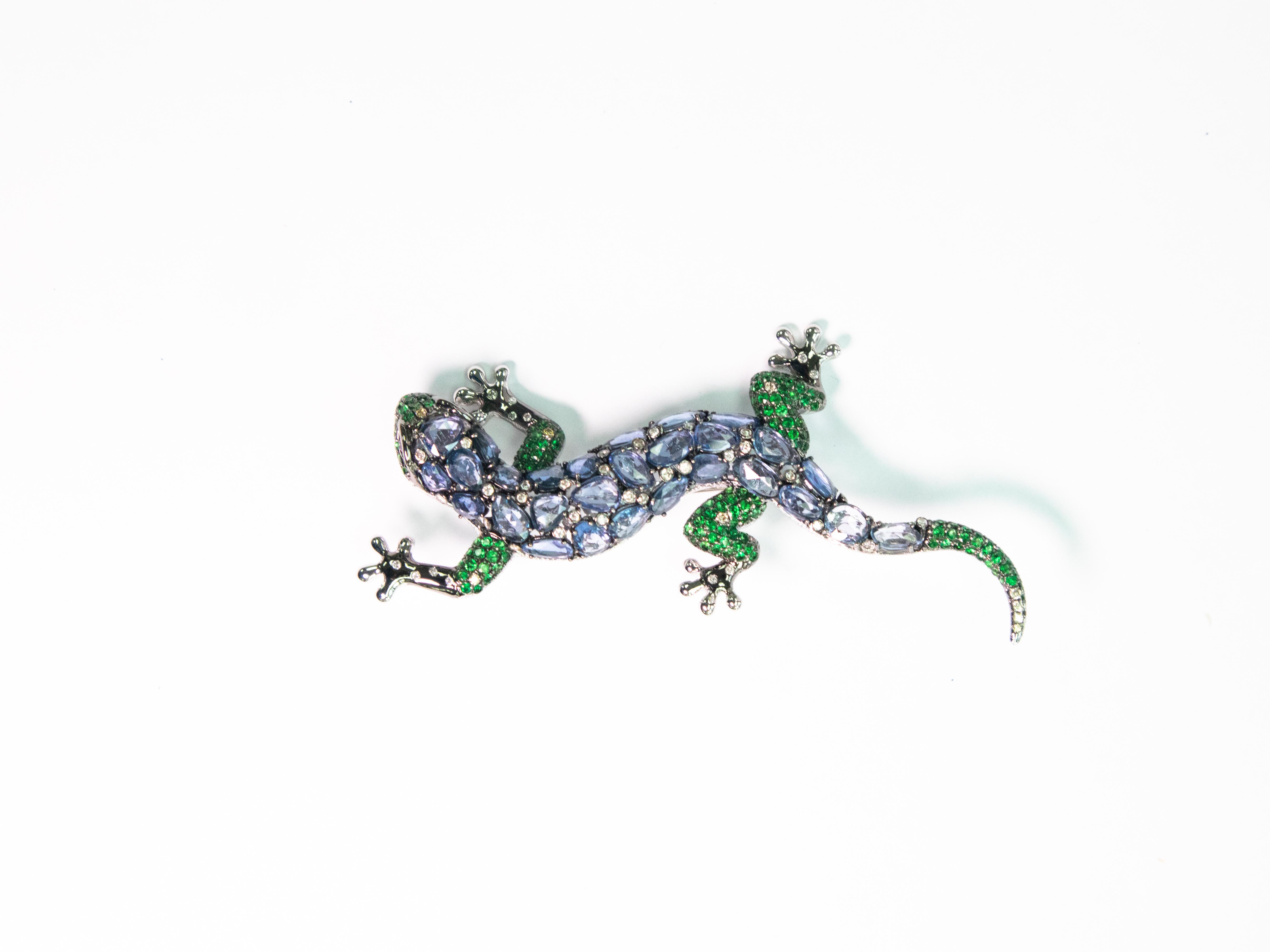 18K White Gold Blue Sapphire and Green Garnet Gecko Brooch
Inspired by the beauty of nature, this mesmerizing gecko brooch is adorned with a dazzling array of blue sapphires and green garnets, set in luxurious 18K white gold. The detailed