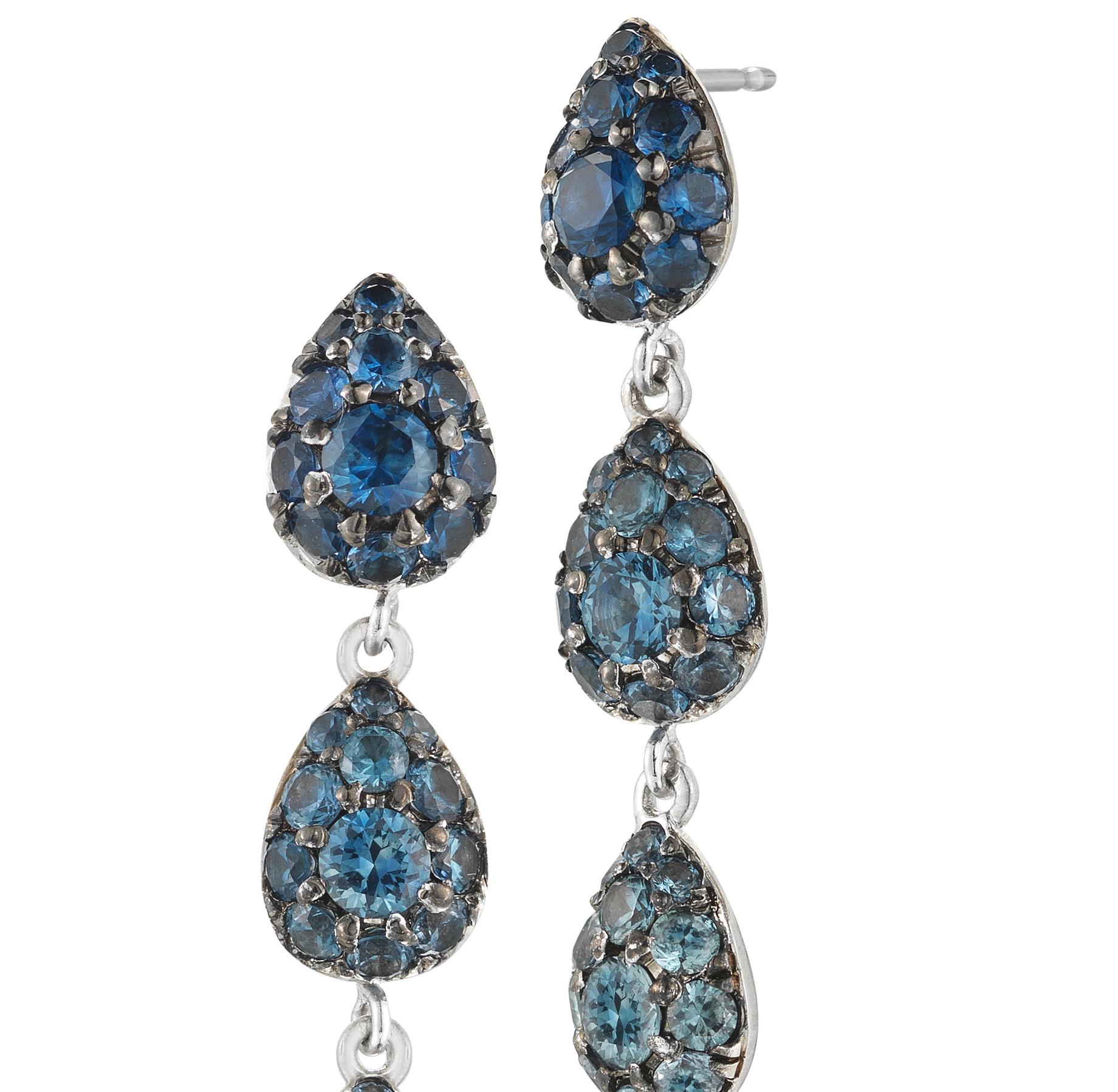 White gold drop earrings are set with gradient blue sapphires. Hand painted with grey rhodium around stones. 

18k white gold 
1.47cts of blue sapphires
complimentary domestic ground 