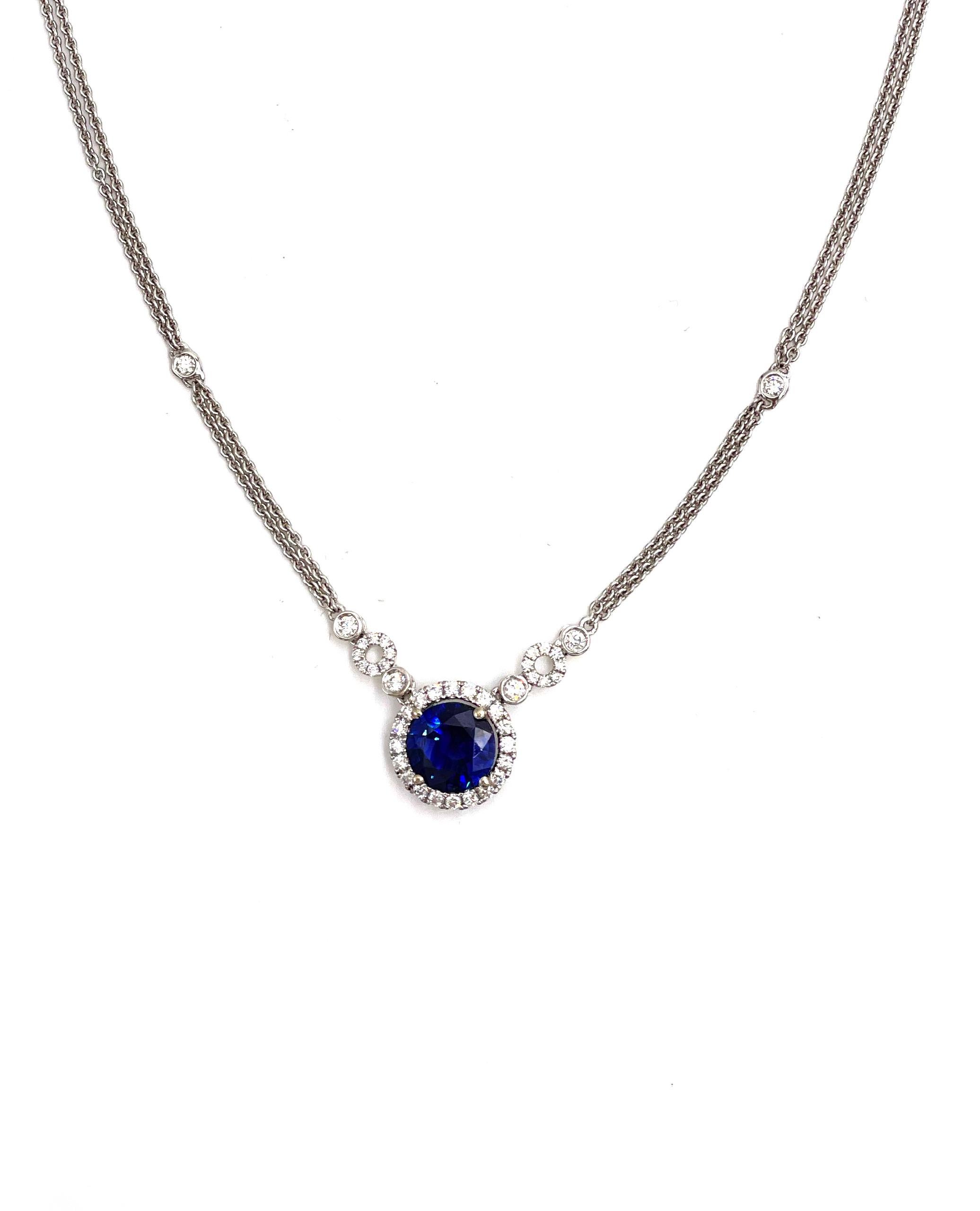 18K white gold double chain halo necklace with accented diamonds on the chain. There are a total of 42 round brilliant-cut diamonds weighing 0.46 carats total weight. In the center there is one round faceted blue sapphire weighing 2.15 carats.

*