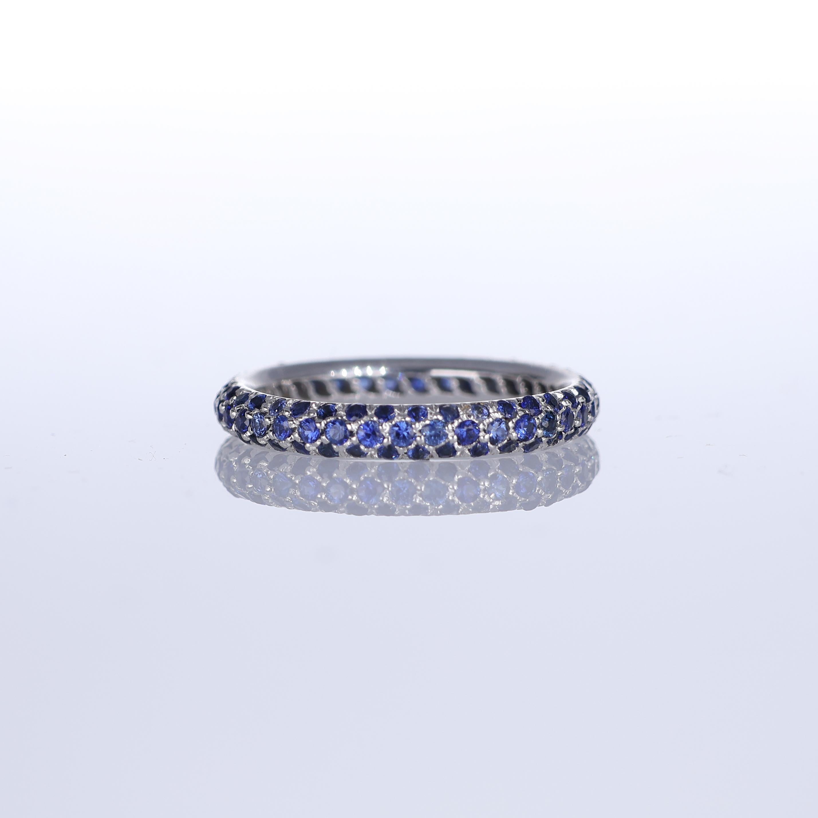 A refined band ring crafted in 18K white gold, featuring a pavé of blue sapphires totaling 1.55 carats. The deep, rich hue of the sapphires is beautifully complemented by the cool brilliance of the white gold, creating a timeless and sophisticated