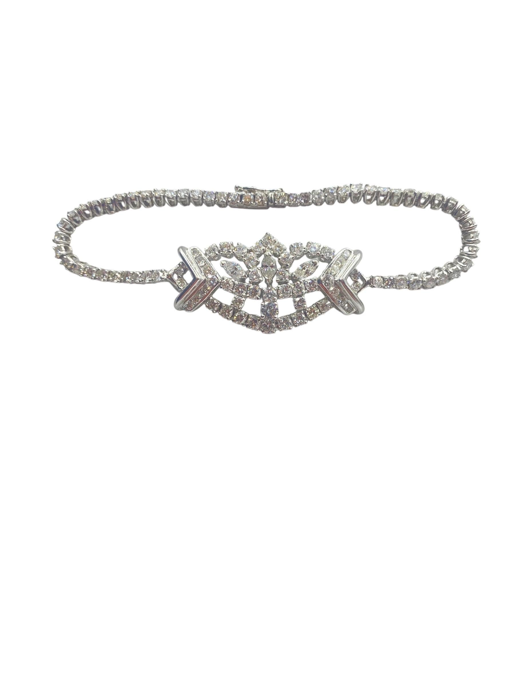 This is an exquisite diamond bracelet featuring a total of 5.60 carats of diamonds with an F color and VS1 clarity rating. The bracelet showcases a delicate design with intricate detailing at the center, where the diamonds are arranged in a
