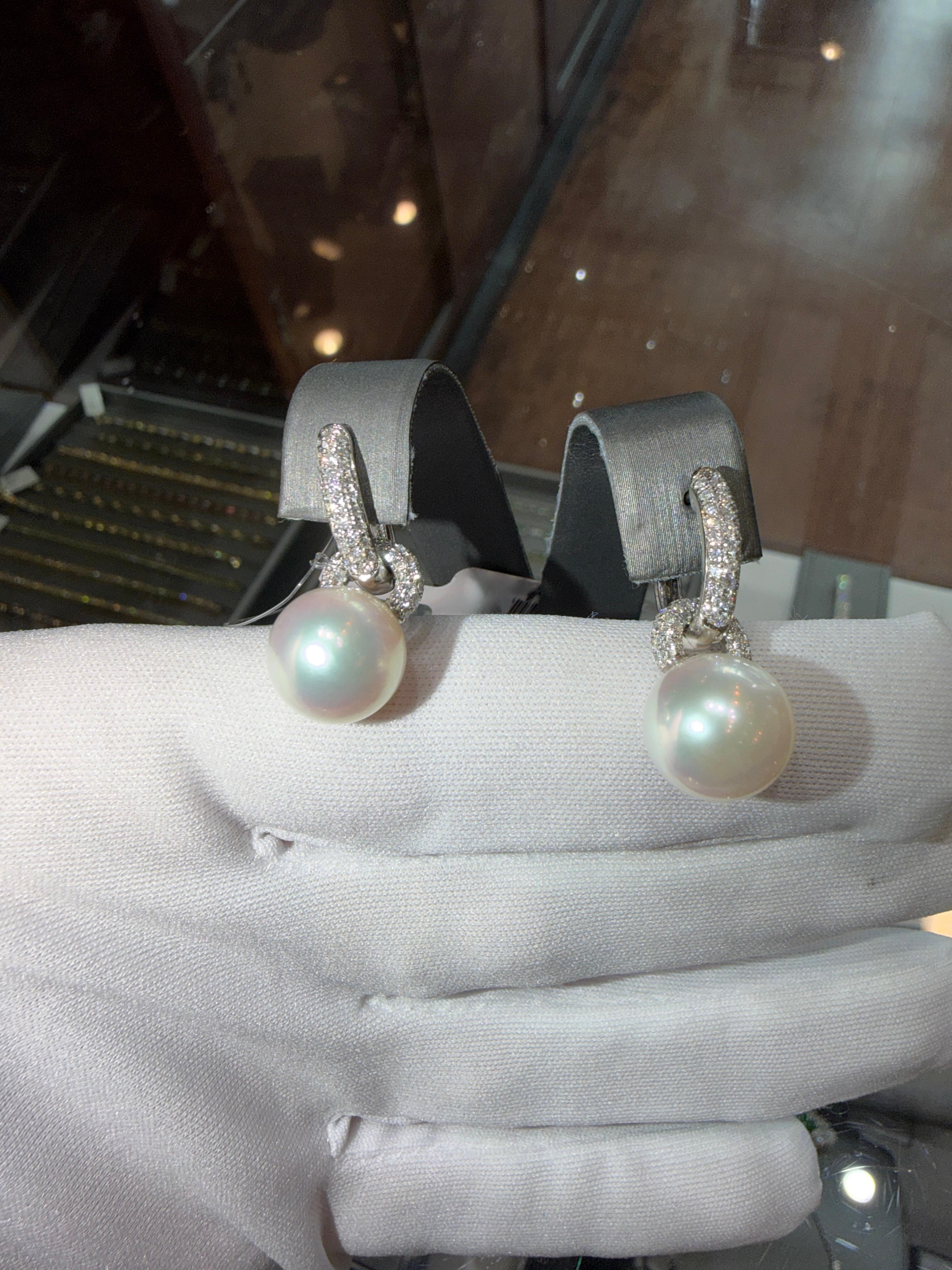 Un paio di orecchini a goccia in oro bianco 18 carati con perle dei mari del sud e diamanti, che combinano l'eleganza contemporanea con la tradizione artigianale. Ogni orecchino presenta una perla dei Mari del Sud di 11,6 mm, perfettamente rotonda e