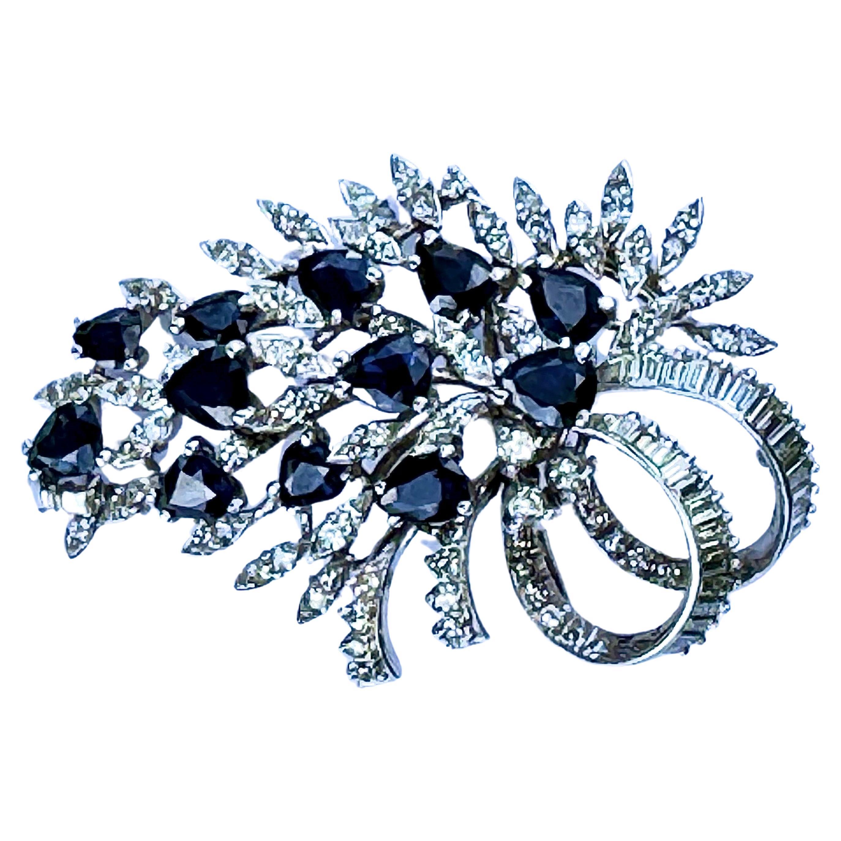 This 18K Sapphire Diamond brooch is unique. Set with over 100 round and baguette diamonds and 12 marquise shaped sapphires totaling over 10 carats. Total weight is 11.64 gms. Measures approximately 2.25 inches long and 1.5 inches wide. Marked 18K on