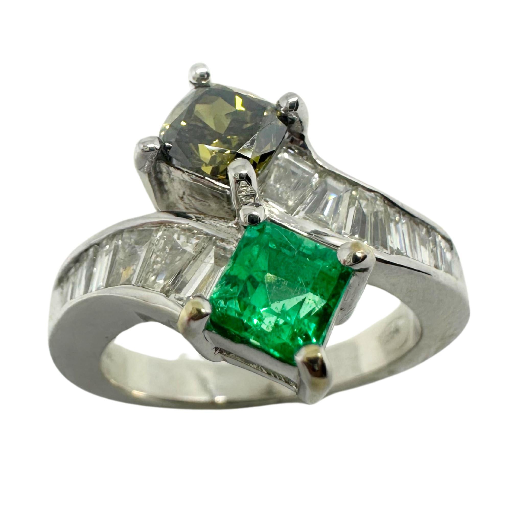 This exquisite 18K White Gold Toi et Moi Ring showcases a striking combination of gemstones, symbolizing unity and contrast. The ring features a 0.71-carat brown diamond and a 0.56-carat emerald, set in an elegant bypass design. Accentuating the