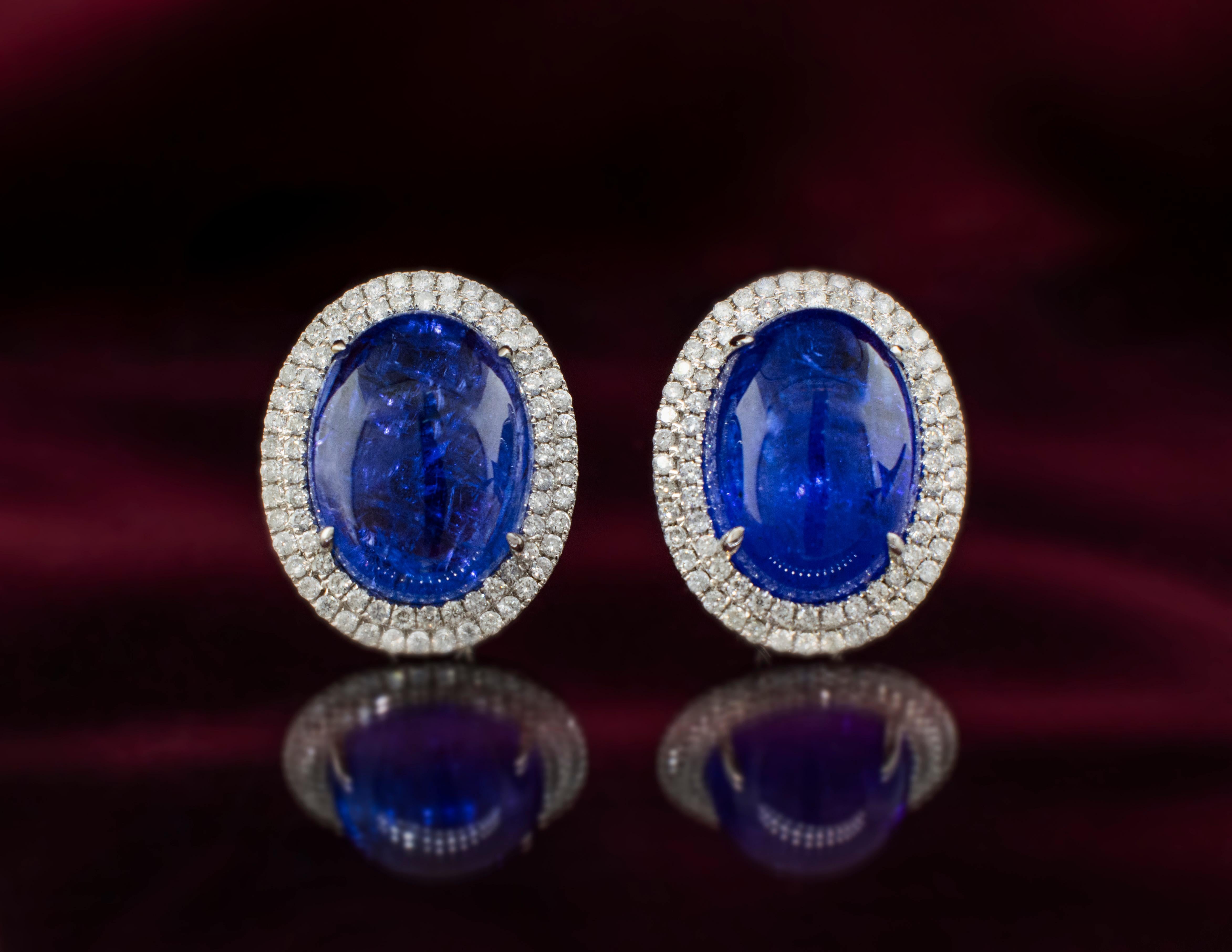 Elegant white gold cabochon Tanzanite and Diamond earrings. The Tanzanite stones are a deep velvety blue with natural inclusions. The cabochon cut gives these stones a smooth domed surface. The combined carat weight of both Tanzanite stones is