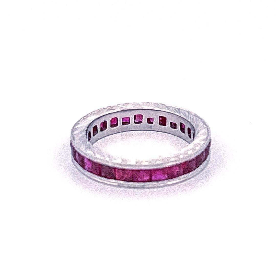 From the Eiseman Estate collection, circa 2010, 18 karat white gold calibre ruby eternity ring. This ring is crafted with 27 channel set square rubies with a combined approximate weight of 3.10 carats. This ring also features hand engraved sides and