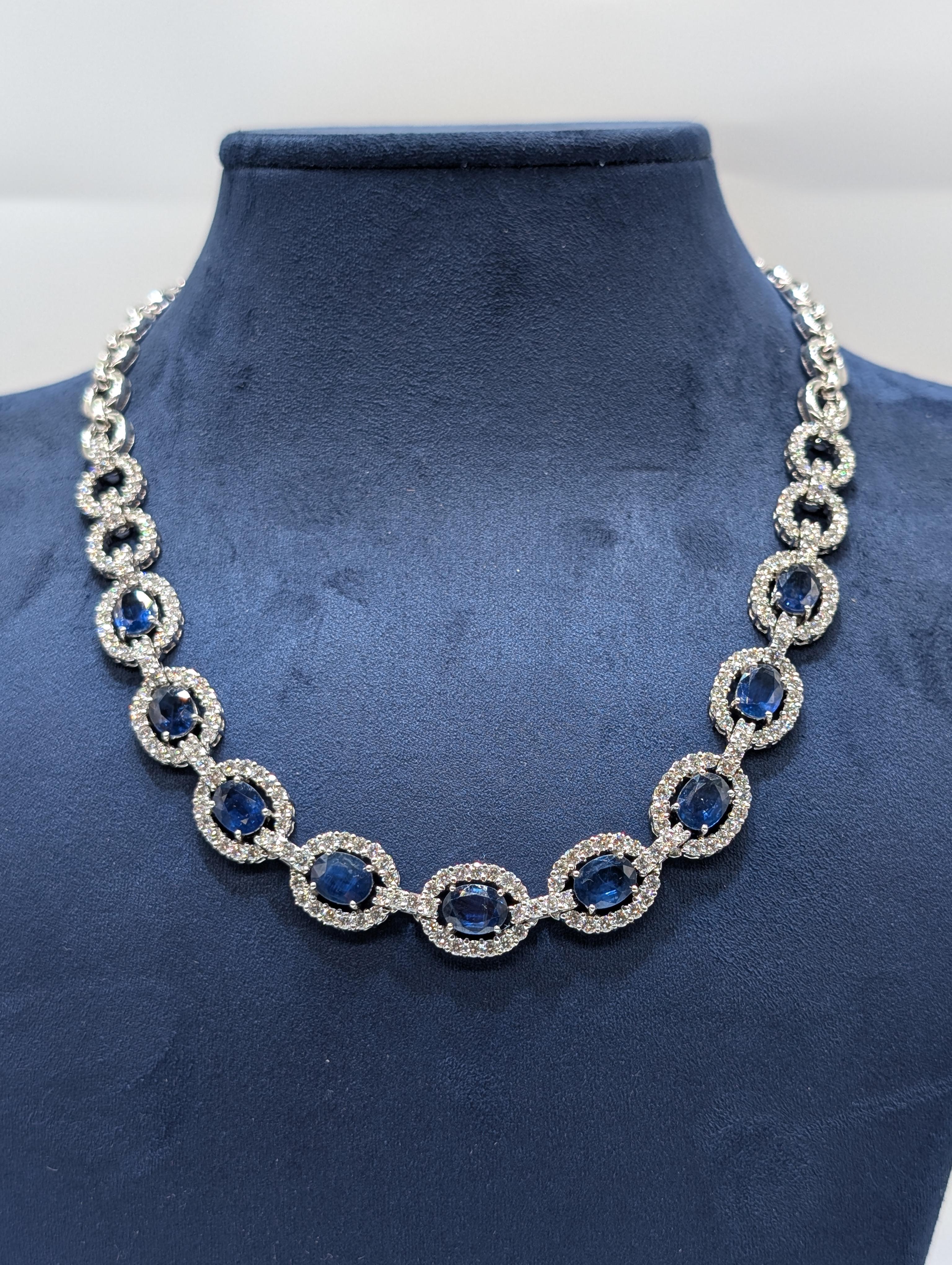This exquisite 18-karat white gold chain necklace features a captivating design with stunning blue sapphires and diamonds. The necklace is highlighted by oval-cut blue sapphires totaling an impressive 12.41 carats, radiating a rich, vibrant hue.