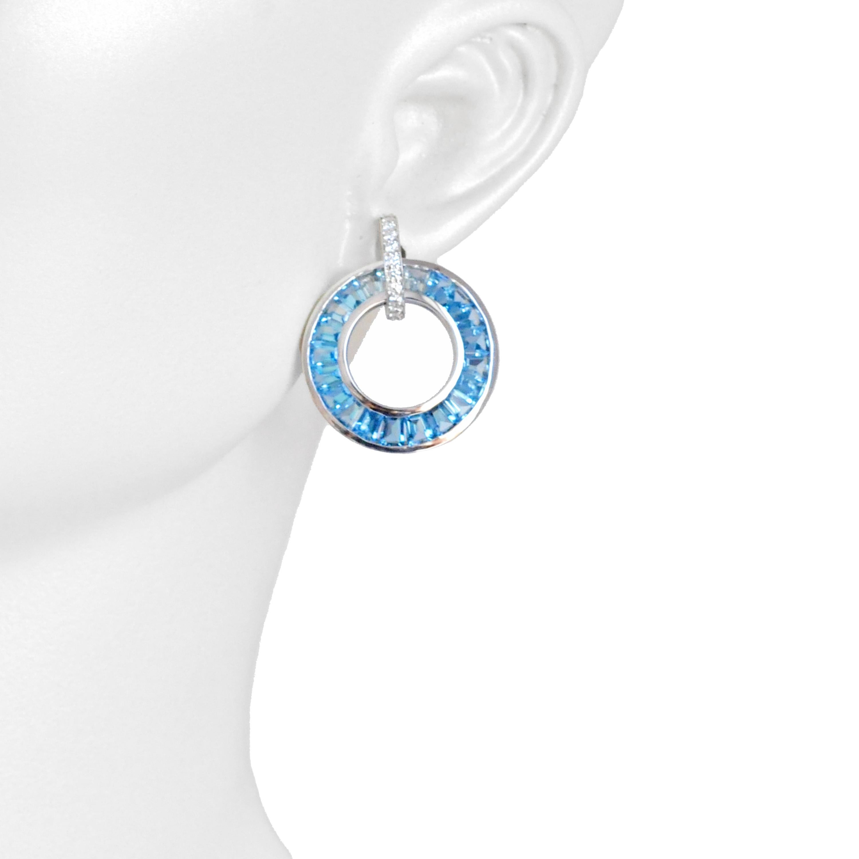 Elevate your style with our stunning 18k white gold tapered baguette blue topaz diamond circle stud earrings, a captivating fusion of elegance and art deco design. These earrings showcase the brilliance of blue topaz stones, each expertly cut into
