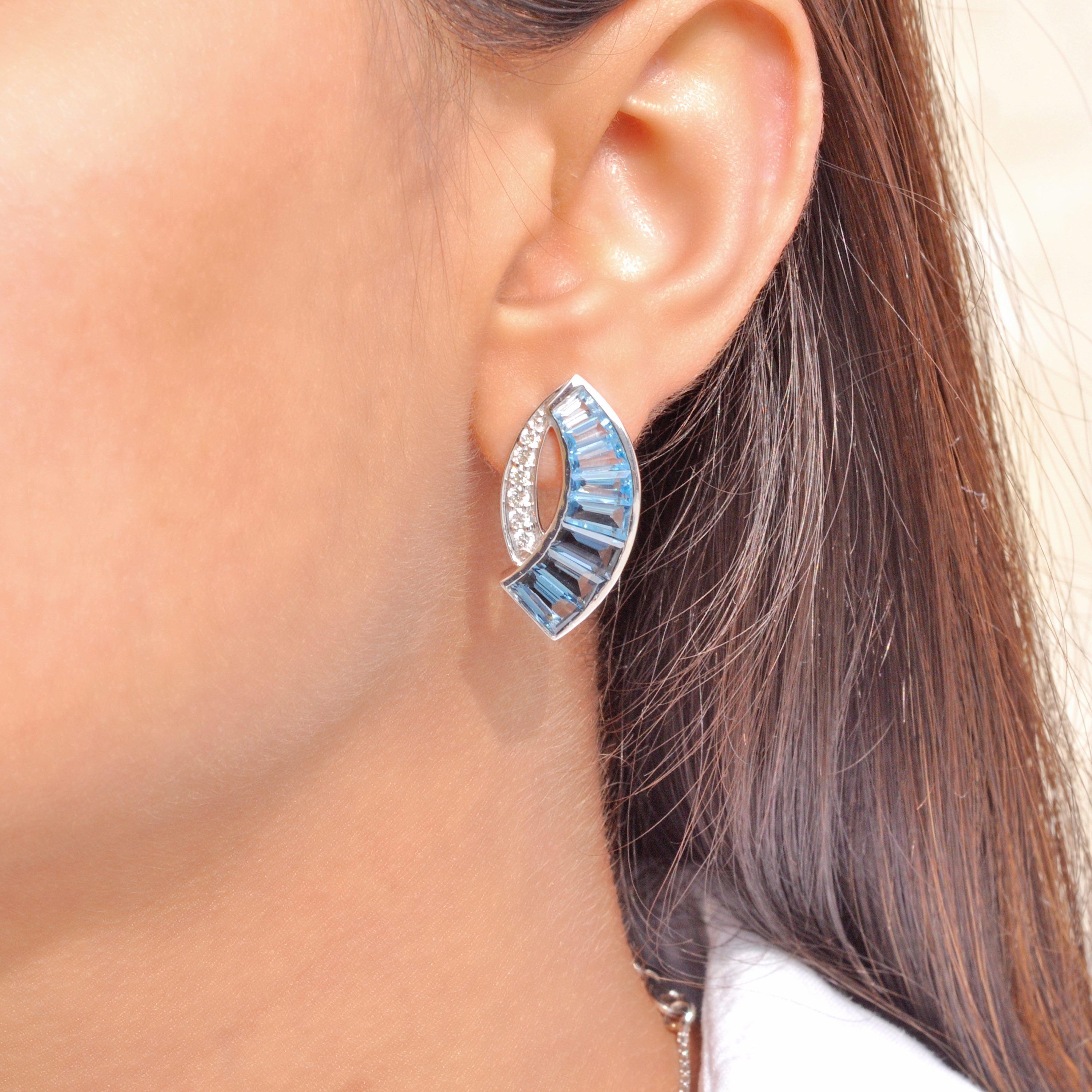 These one-of-a-kind stud earrings in 18-karat white gold embody artistic brilliance and unparalleled craftsmanship. Designed in a striking sword shape, the earrings feature a mesmerizing gradient of channel-set blue topaz tapered baguettes. Each
