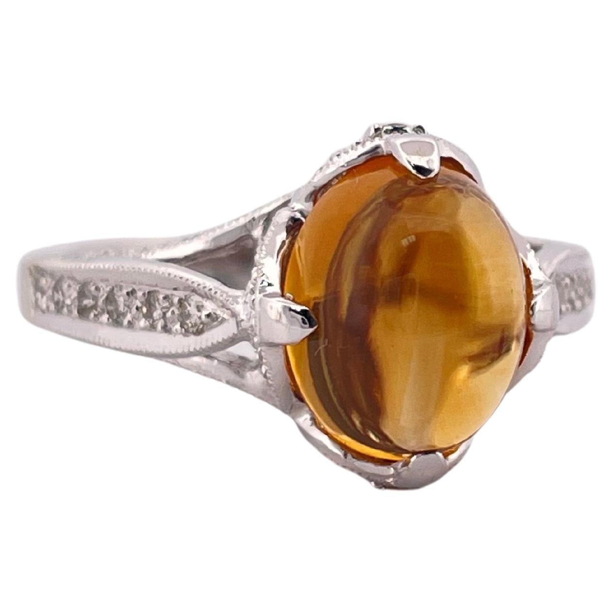 Cette exquise bague en or blanc 18 carats, pesant 6,3 grammes, met en valeur une citrine vibrante comme pièce maîtresse, rayonnant de chaudes teintes orangées dorées avec une brillance captivante. La pierre précieuse est habilement sertie dans une