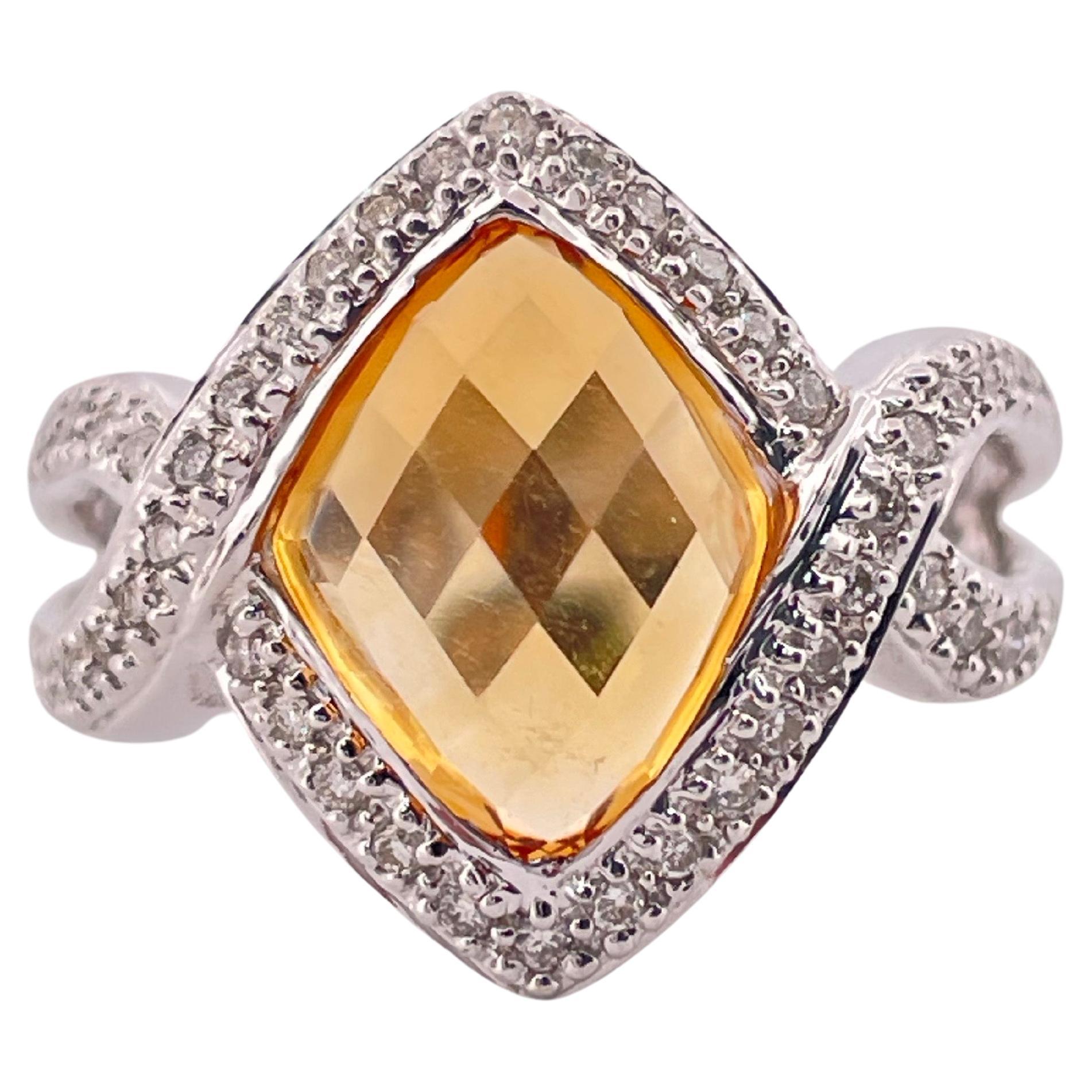 Cette élégante bague en or blanc 18 carats est ornée en son centre d'une citrine à facettes en damier, aux riches teintes dorées et à l'éclat exceptionnel. La citrine est taillée en forme de cerf-volant et sertie dans un halo de diamants ronds