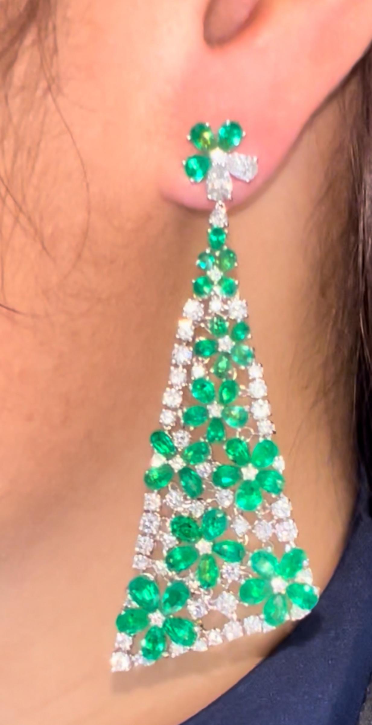 Un paio di orecchini di alta gioielleria mozzafiato, disegnati con un'audace silhouette a lampadario triangolare e incastonati con una straordinaria combinazione di smeraldi colombiani e diamanti bianchi. Forgiati a mano in oro bianco massiccio 18