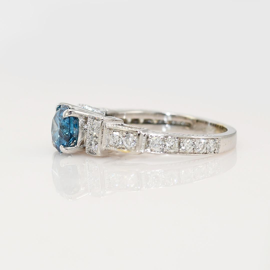 18K White Gold Color Enhanced Diamond Ring, 5.9gr

Ladies diamond engagement ring in 18k white gold setting.
Stamped 18k and weighs 5.7 grams gross weight.
The center diamond is color enhanced  blue color, similar to topaz blue, approximately 1.06