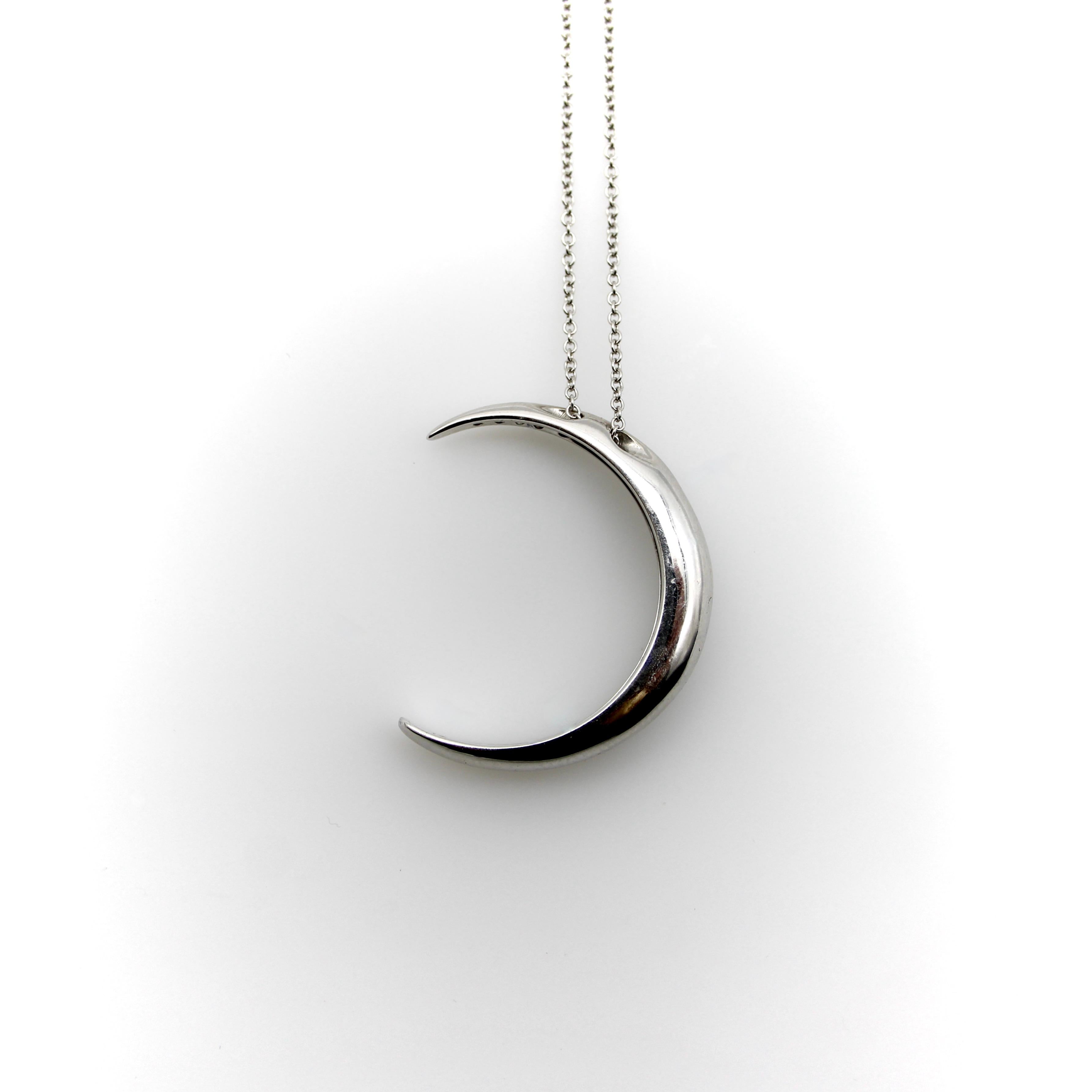 This 18k white gold crescent moon necklace is encrusted with sparkling diamonds. The crescent moon has a rounded shape, with wonderful dimension—when it hangs from the chain it has depth that draws the eye to this excellent piece. Circa 1980’s, this