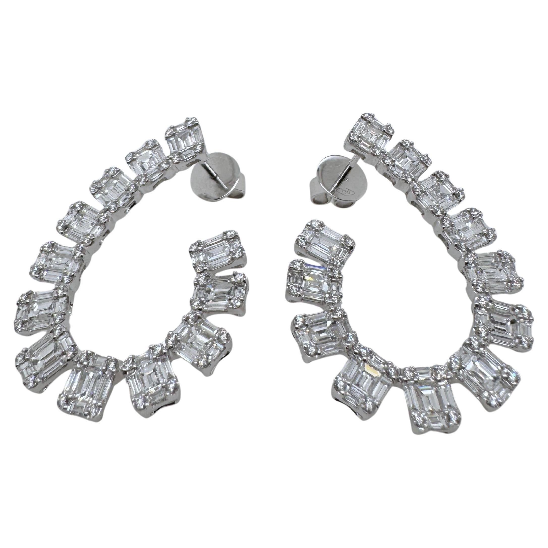 Add a touch of modern elegance to your jewelry collection with these stunning 18K white gold diamond earrings. Designed in a unique curved silhouette, each earring features a dazzling row of alternating baguette-cut diamonds and round brilliant