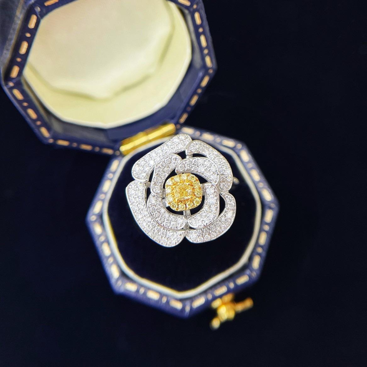 Dieser exquisite Ring aus 18 Karat Gelbgold zeichnet sich durch ein dimensionales Blumenmotiv aus, in dessen Mittelpunkt ein natürlicher Diamant im Kissenschliff (0,10 Karat) steht, der von 0,40 Karat Diamanten in Pavé-Fassung umgeben ist, die