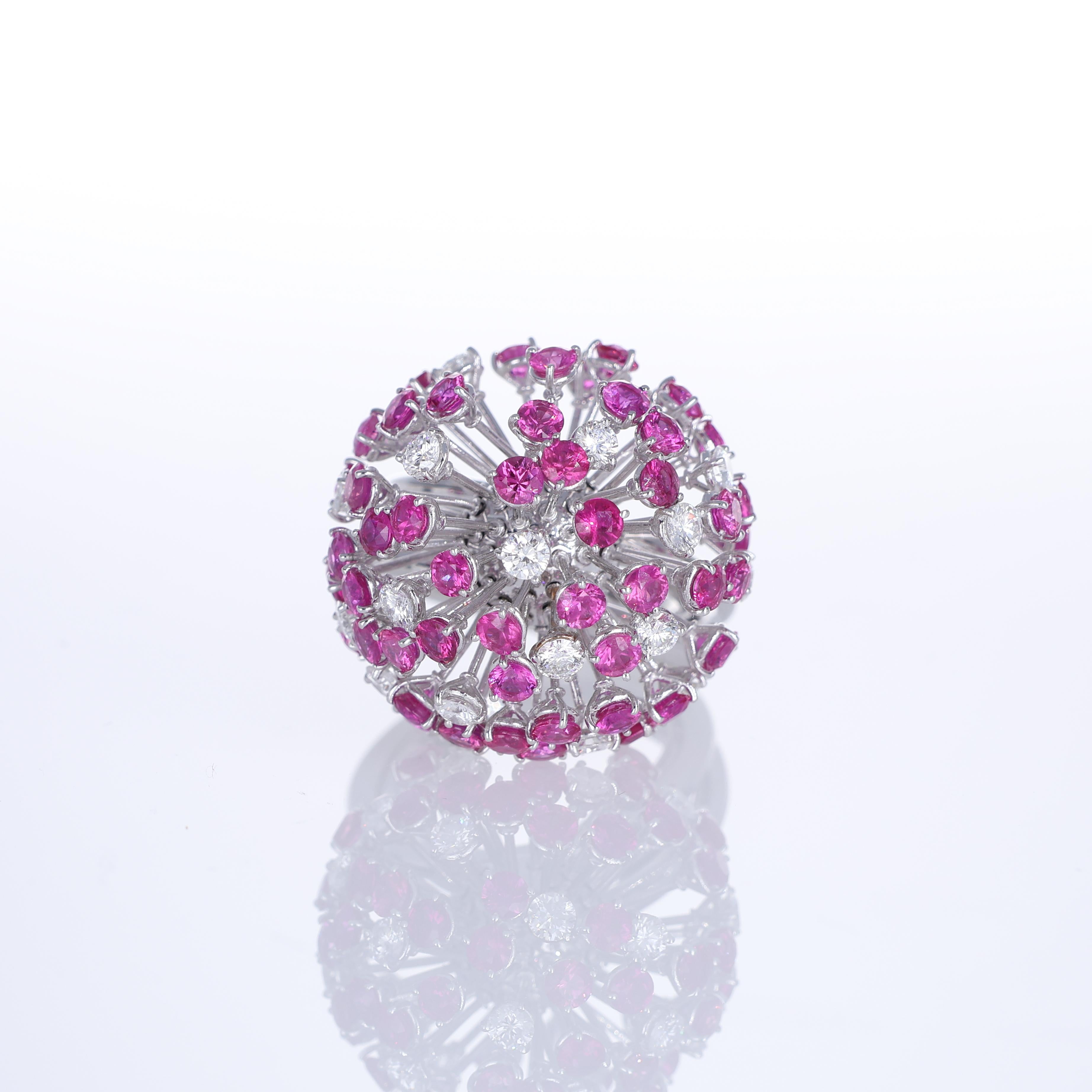 An artistic 18K white gold ring designed in the shape of a delicate dandelion, capturing movement and light with its intricate structure. The dynamic composition is adorned with brilliant-cut white diamonds and vibrant pink sapphires, creating a