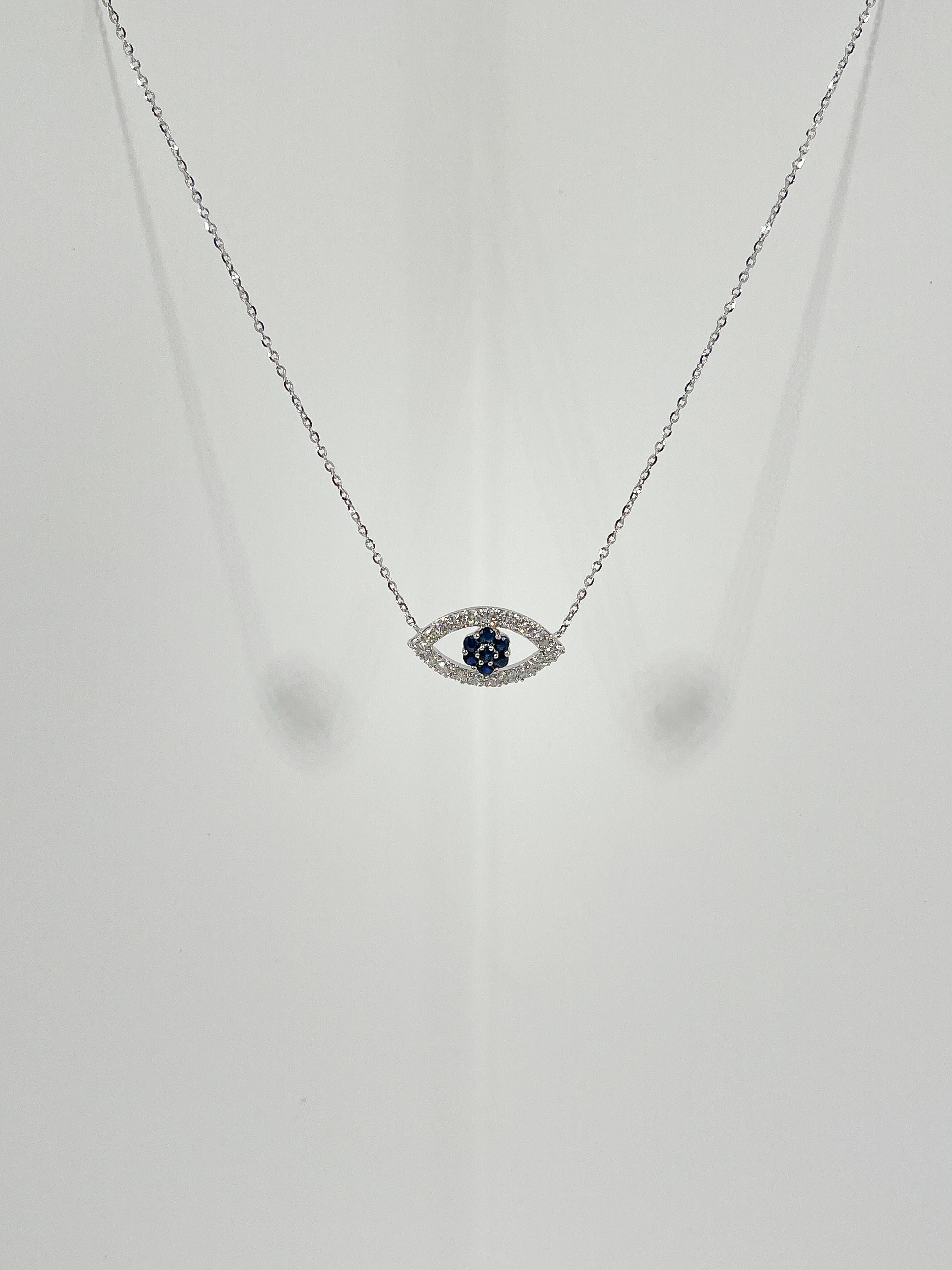 18k white gold diamond .50 CTW and sapphire .24 CTW evil eye pendant necklace. The necklace is 18 inches long, pendant has diamonds on the outside of the eye and sapphires as the iris. Pendant measures 9 x 16.6 mm and necklace has a total weight of