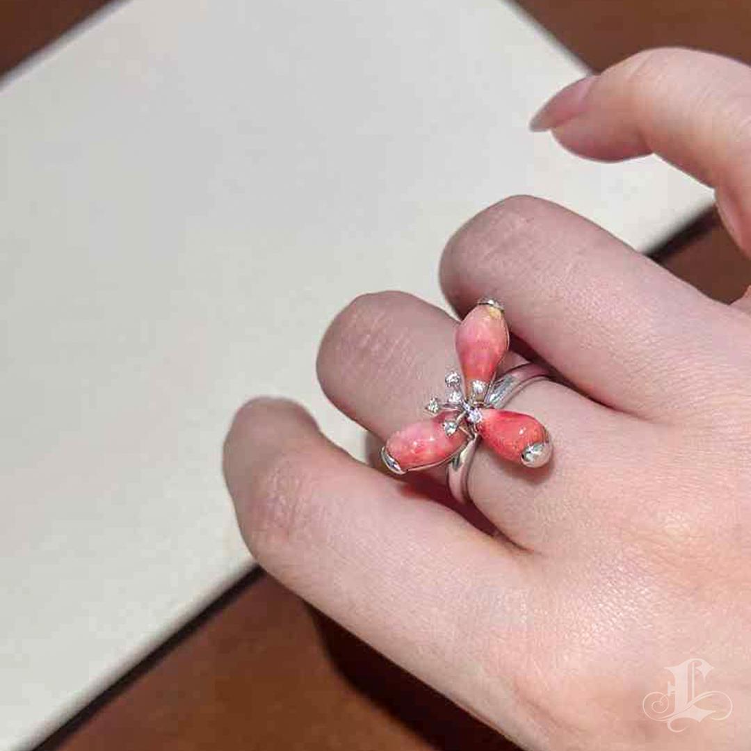 Bold and expressive, this sculptural floral ring blossoms with three natural conch pearls totaling 6.7ct, each in a luminous orangey-pink hue with distinct moderate flame patterns. Set as open petals around a stamen of twinkling diamonds, the pearls