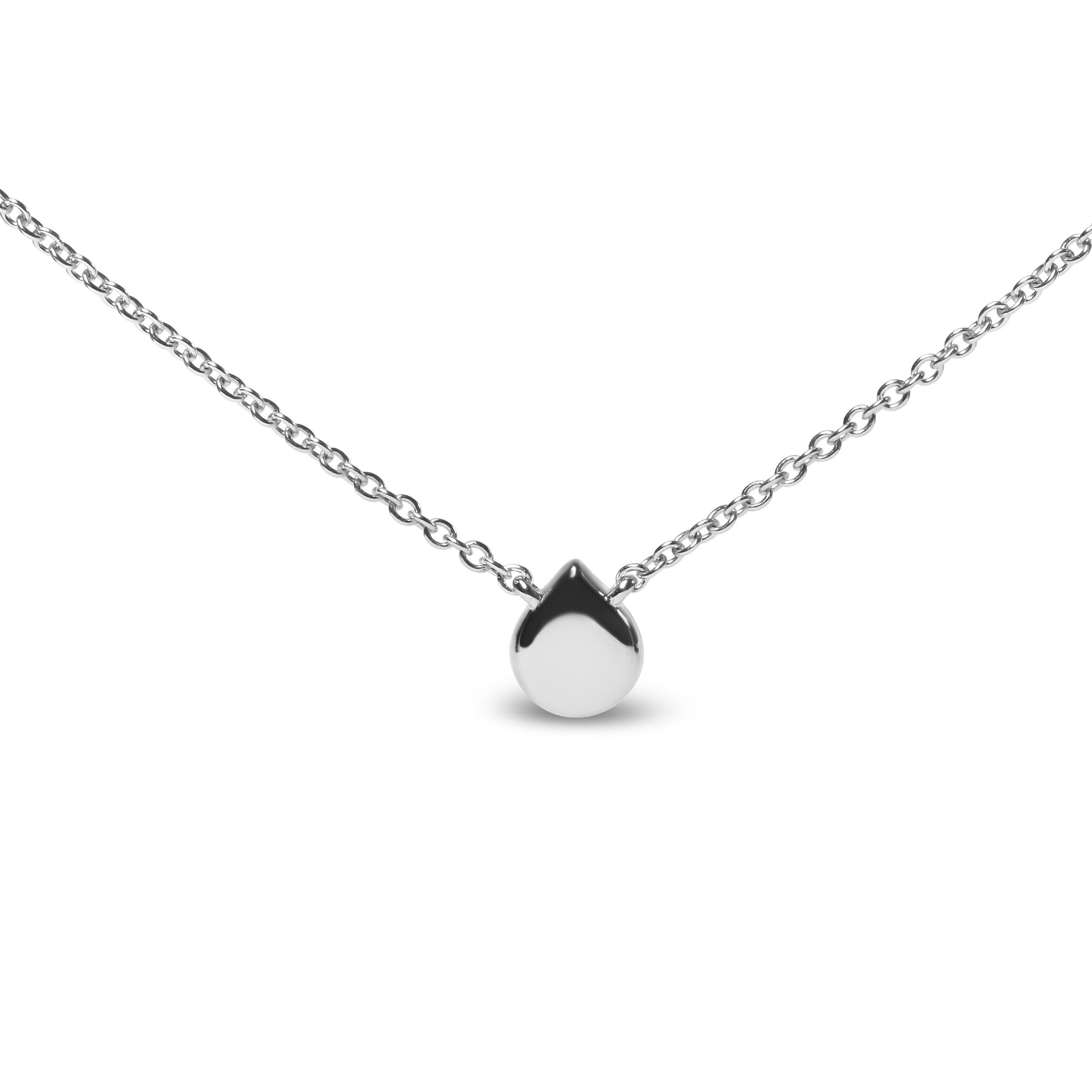 This stunningly unique pendant necklace is crafted of genuine 18k white gold featuring a round diamond accent stone in a prong setting that is haloed by natural 1mm round heat-treated blue sapphires. This solitaire diamond accent is of an