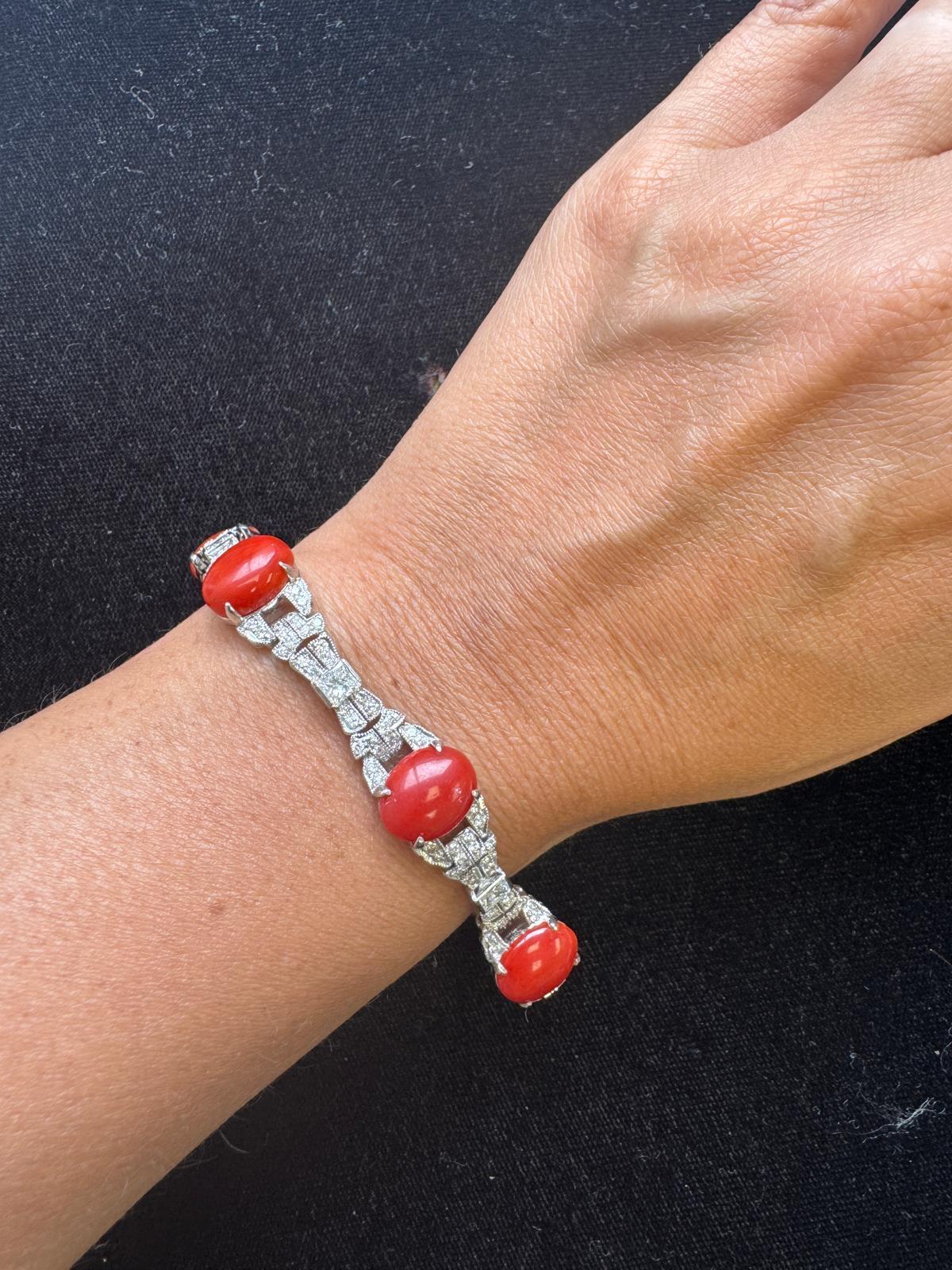 Uno squisito bracciale in oro bianco 18 carati con cinque coralli ovali cabochon riccamente colorati, ciascuno incorniciato da scintillanti diamanti rotondi a taglio brillante. Le maglie geometriche incastonate di diamanti creano un ritmo fluido ed