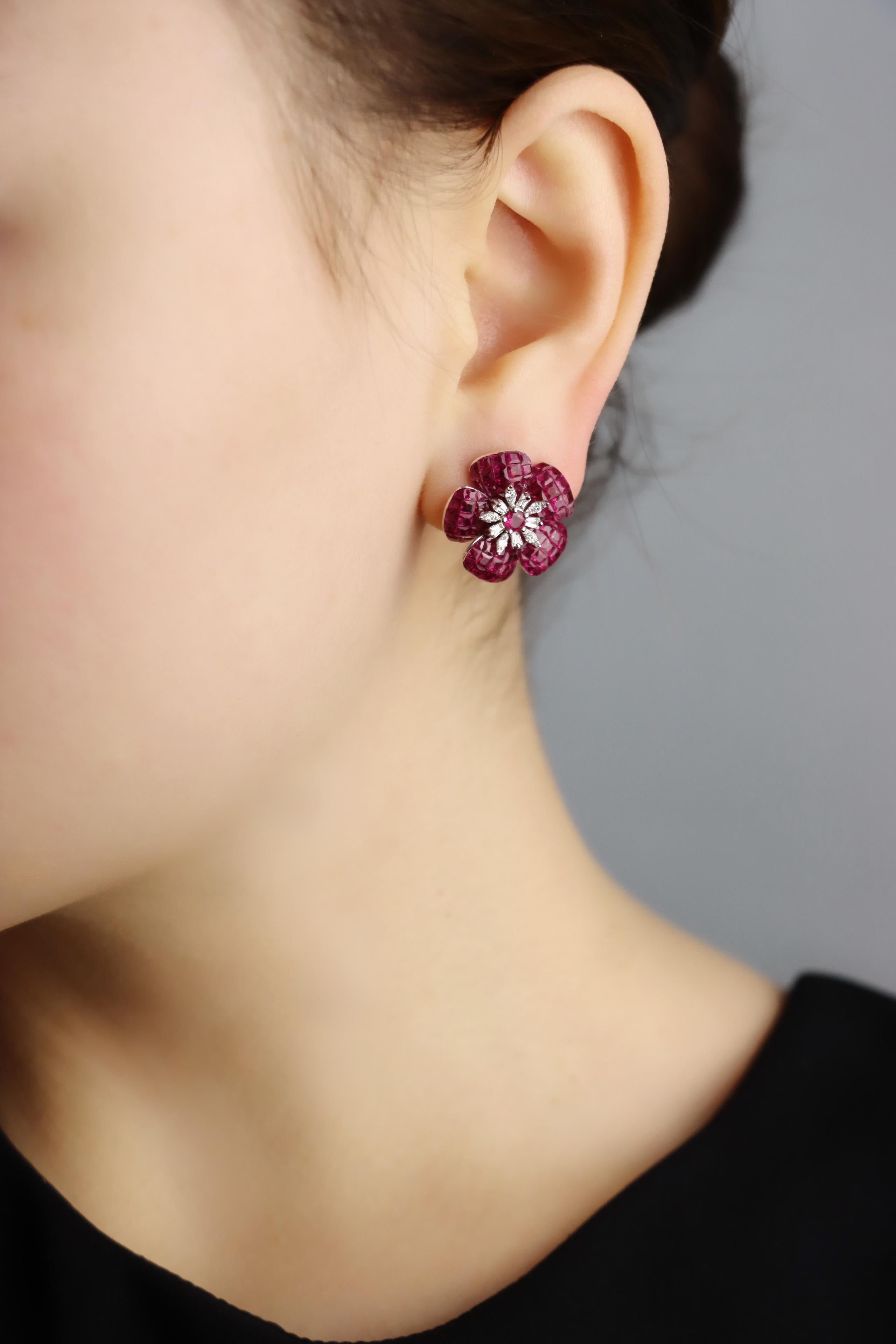 18K White Gold Diamond and Mystery Set Ruby Flower Earrings

Marked:
K18 750
D 0.23 ct
R 3.00 ct

Approximate Dimensions:
1.8 cm (Length) 
1.8 cm (Width)
6.0 carat (Ruby)
0.46 carat (Diamonds)
10.54 grams in weight.