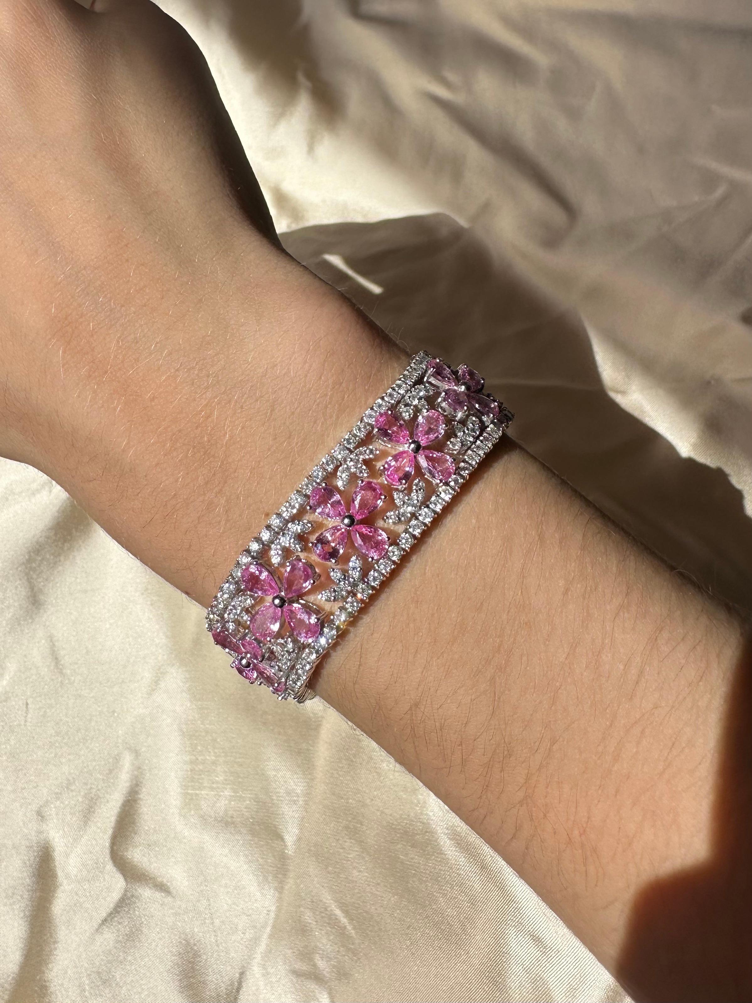 Un bracelet floral vibrant et complexe, composé de saphirs roses taillés en poire et de diamants ronds sertis en or blanc 18 carats. Les saphirs roses sont disposés dans un motif floral. Les fleurs sont entourées de 7,87 carats de diamants. Le