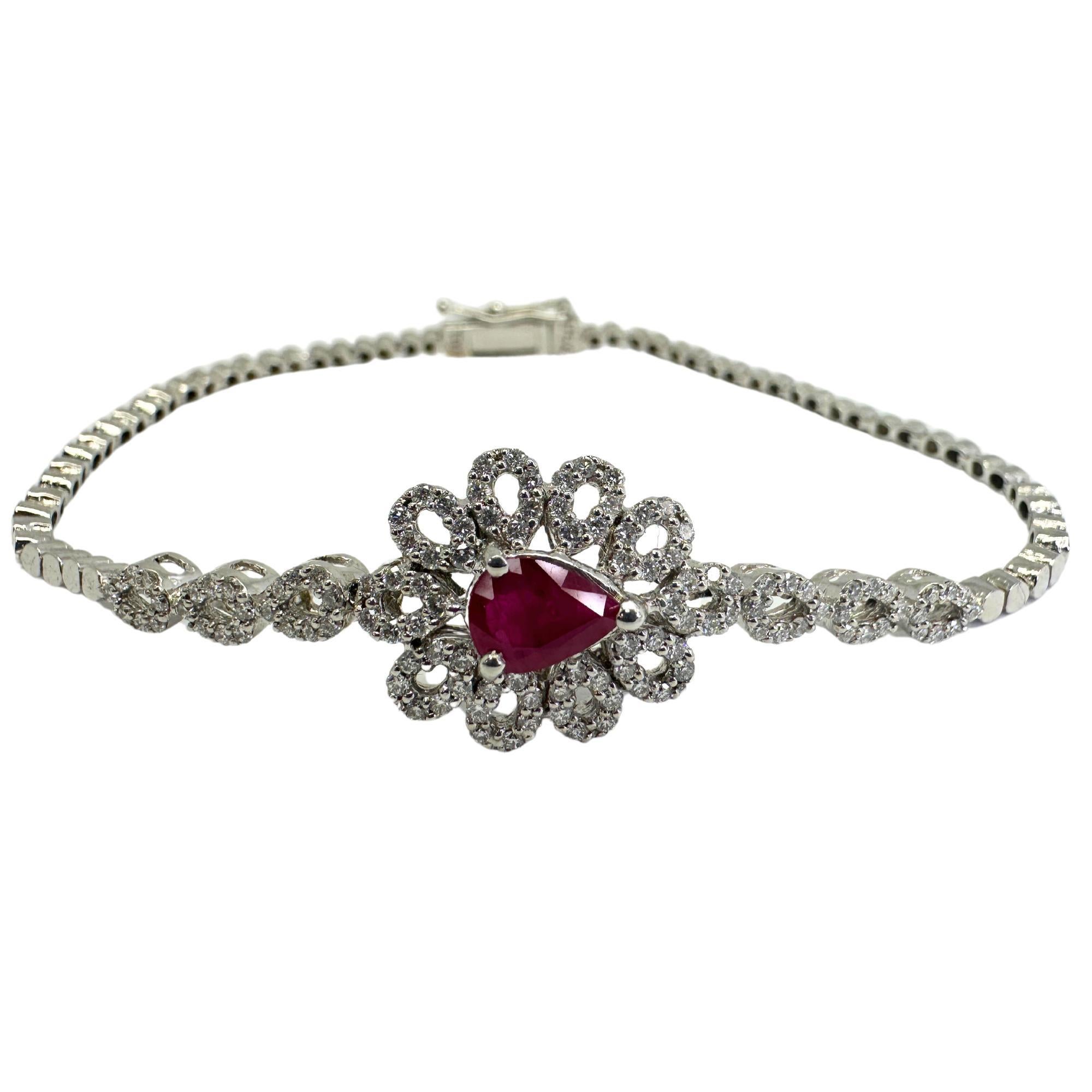 Questo elegante bracciale in oro bianco 18 carati presenta splendidi rubini a forma di pera e 0,75 carati di diamanti scintillanti. In buone condizioni, con lievi segni di usura, questo bracciale da 7,5 pollici è un'aggiunta senza tempo a qualsiasi