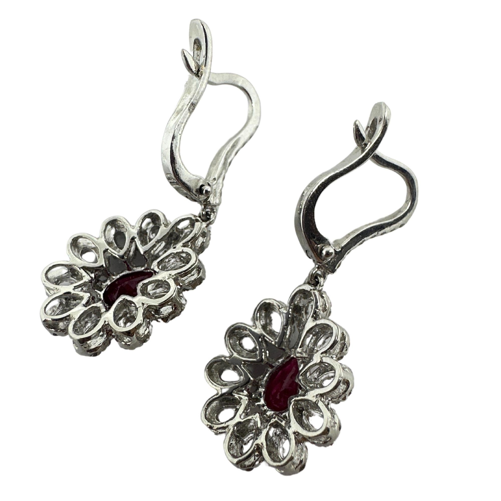 Add a pop of color to any outfit with these elegant 18k White Gold Diamond and Pear Shaped Ruby Earrings. These stunning earrings feature 1.56 carats of sparkling diamonds and 1.42 carats of deep red ruby, all set in 18k white gold. At 1.25 inches