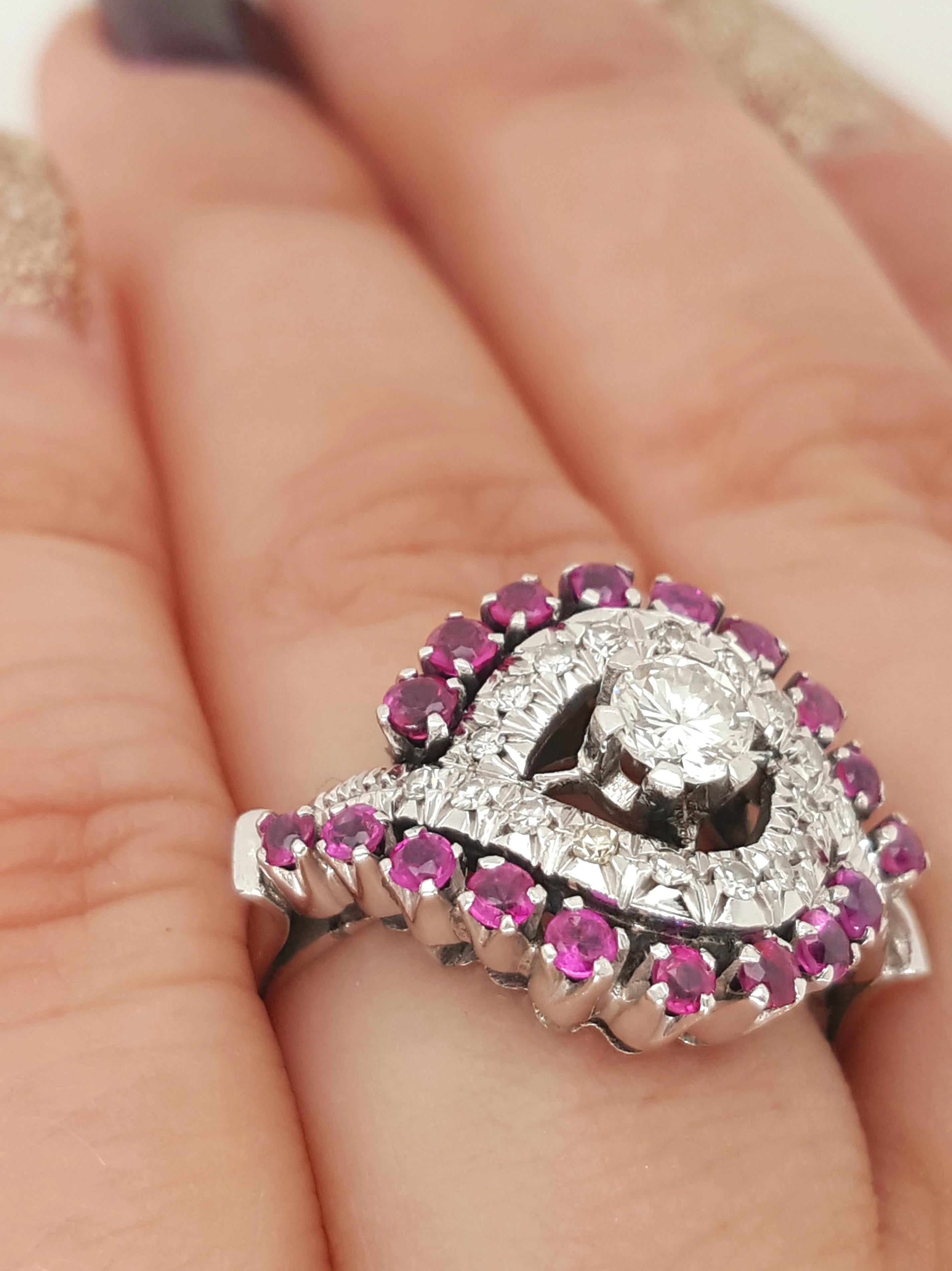 Anillo de oro blanco de 18 quilates de diamantes y rubíes, con un diamante central redondo de talla brillante.   Este anillo de bello diseño, de hacia 1940, presenta un diamante central de aproximadamente 0,27 quilates,  VS claridad  I - J  color.  