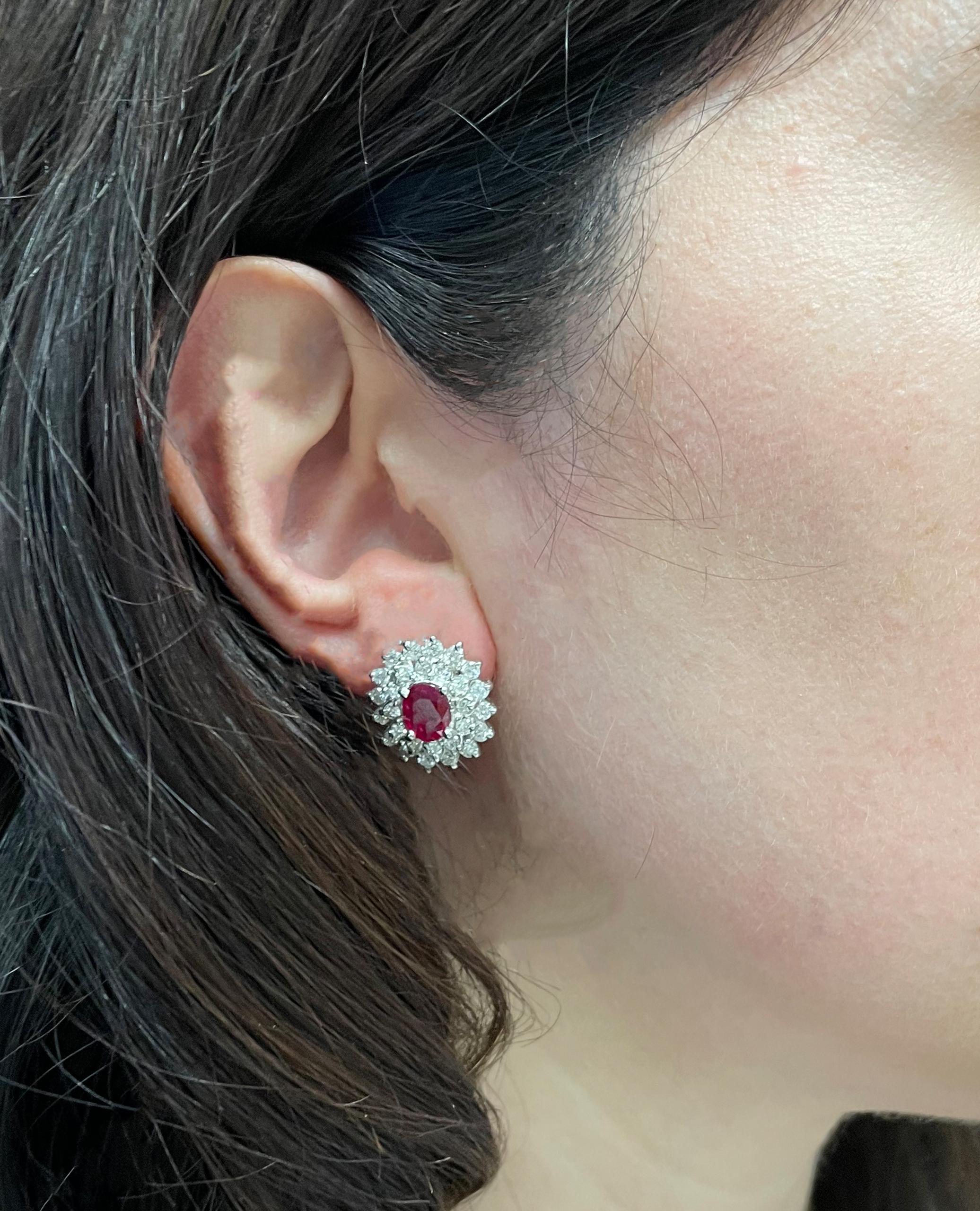 Pair of 18K white gold earrings furnished with round faceted diamonds weighing 3.00 carats total and two oval shaped faceted rubies weighing 2.00 carats total. Rubies measure 5x7mm each. 

- Omega back closures (lever clip backs)