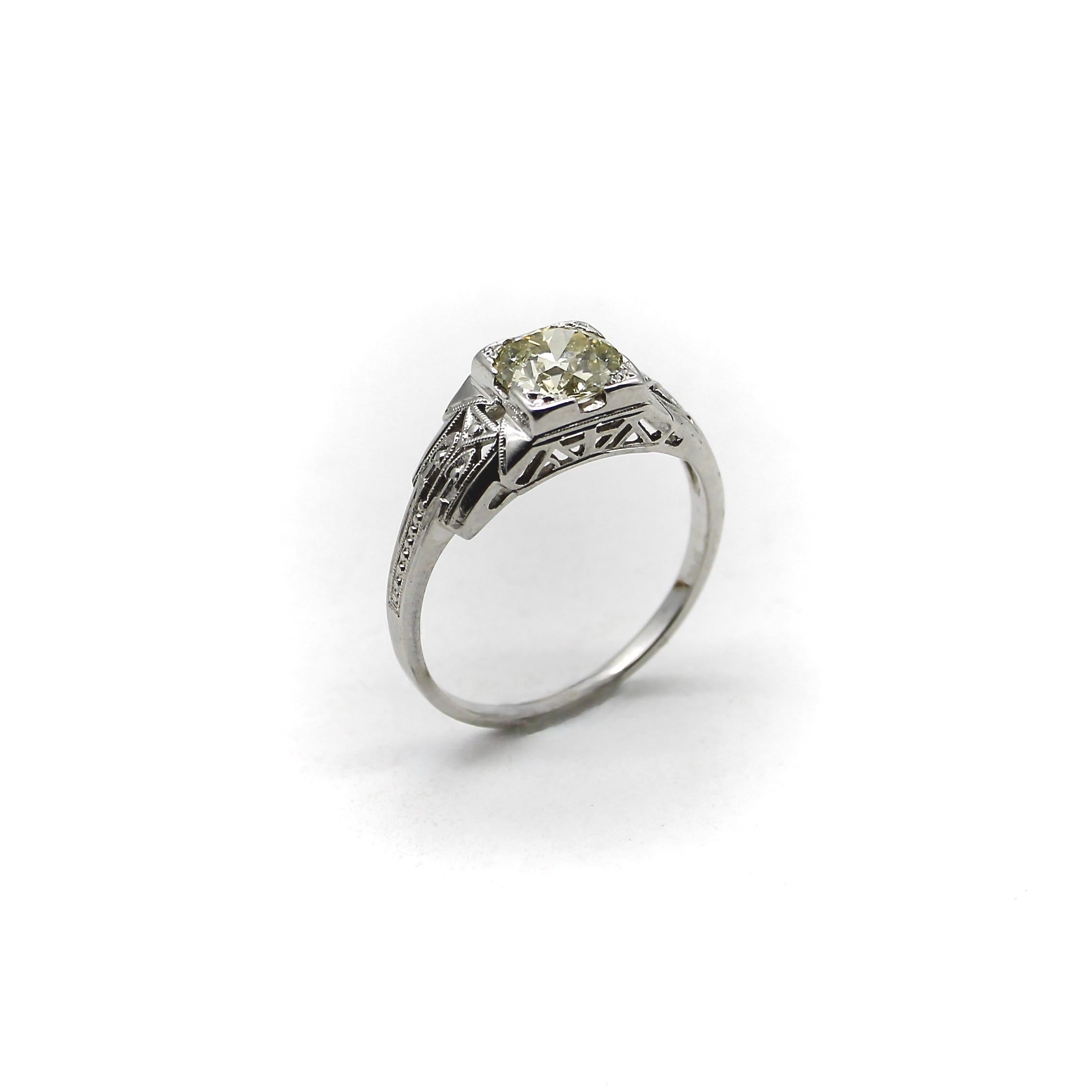 Circa 1920, this diamond engagement ring captures the transition from Edwardian filigree to the geometric and architectural details of Art Deco, incorporating both eras in its lovely design. The Old European cut diamond has a phenomenal sparkle